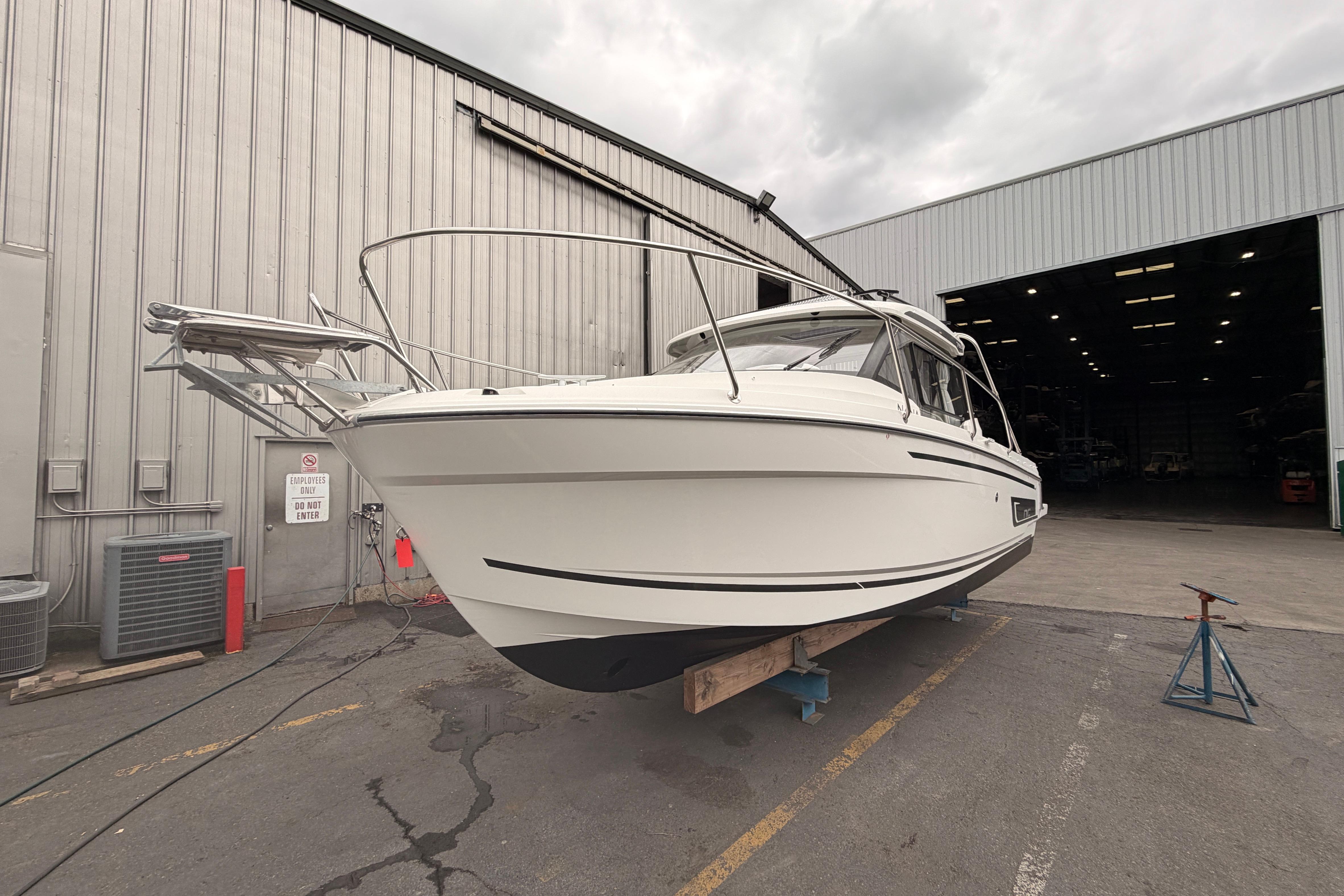 2026 Jeanneau NC Weekender 795 Series 2 boat in a shipyard, side view.