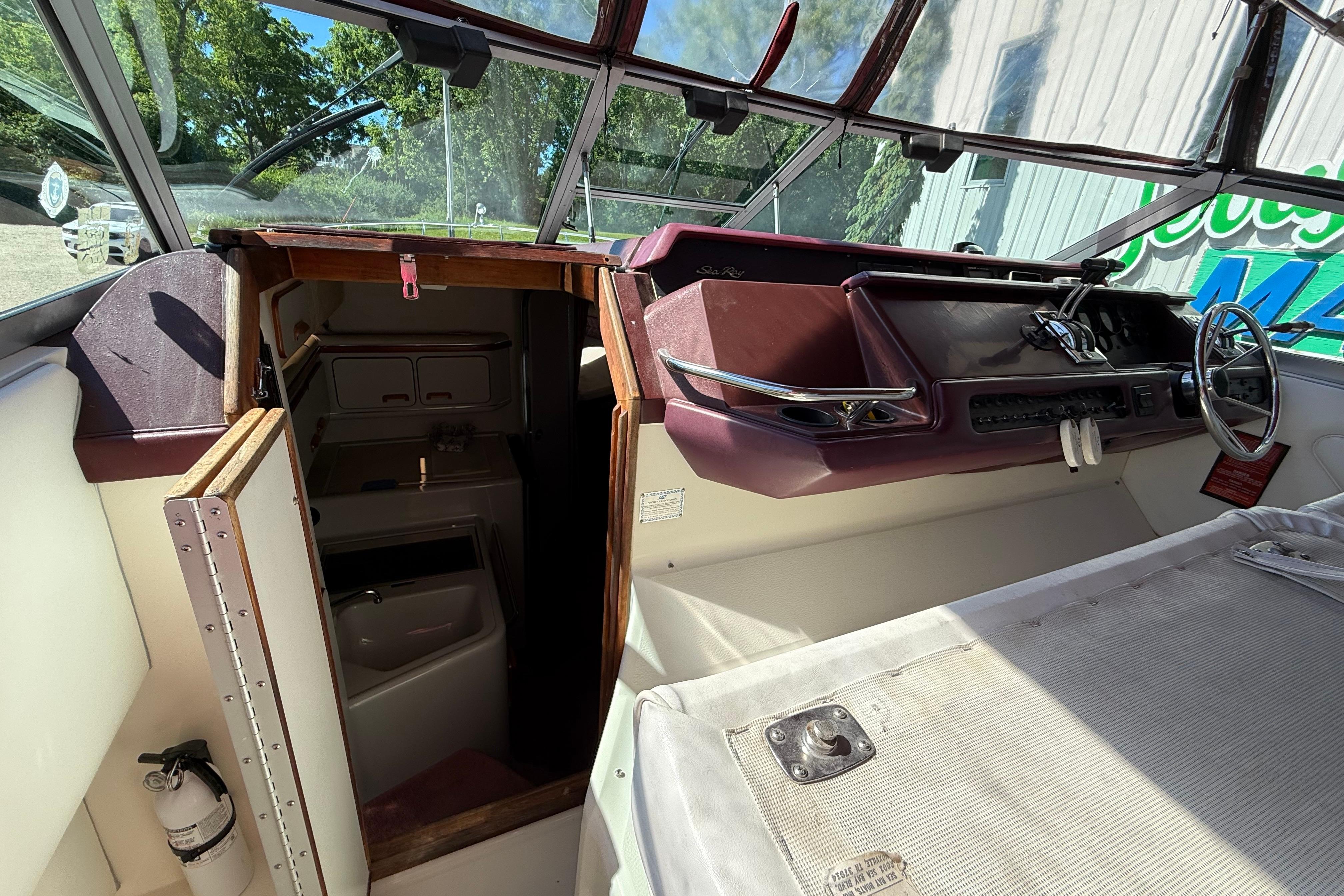 1990 Sea Ray 310 Express Cruiser cockpit with steering wheel and cabin entrance.