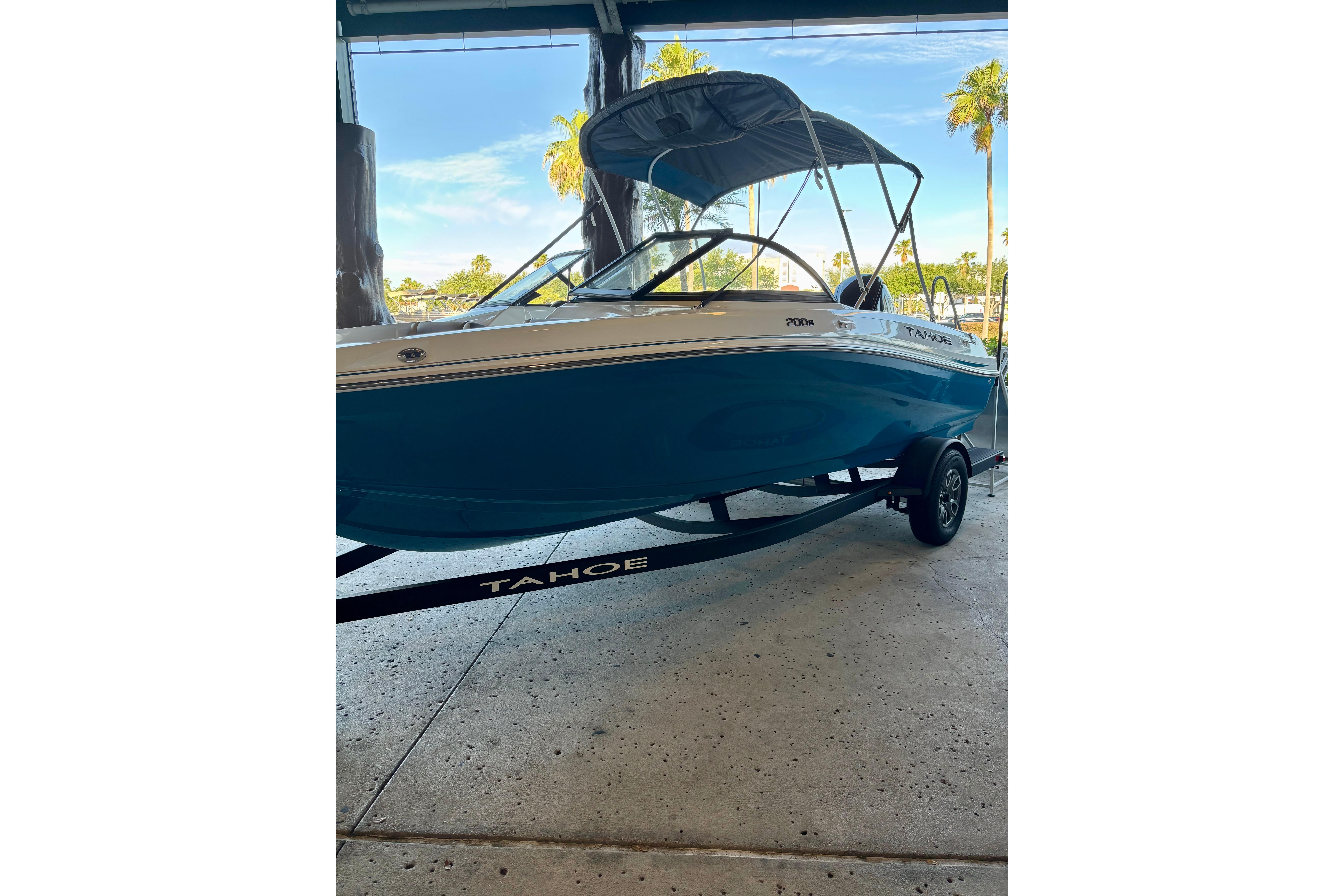 2025 Tahoe 200 S boat on trailer, blue hull, parked indoors.