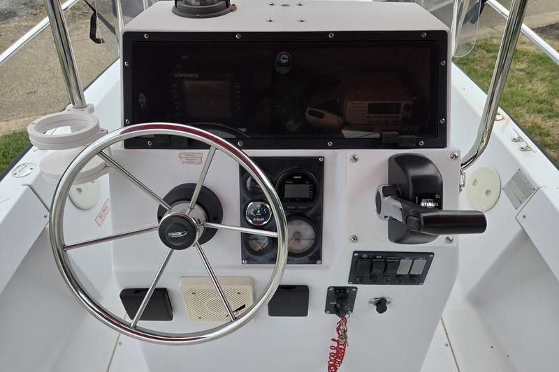 1996 Boston Whaler Outrage 17 boat console with steering wheel and controls.