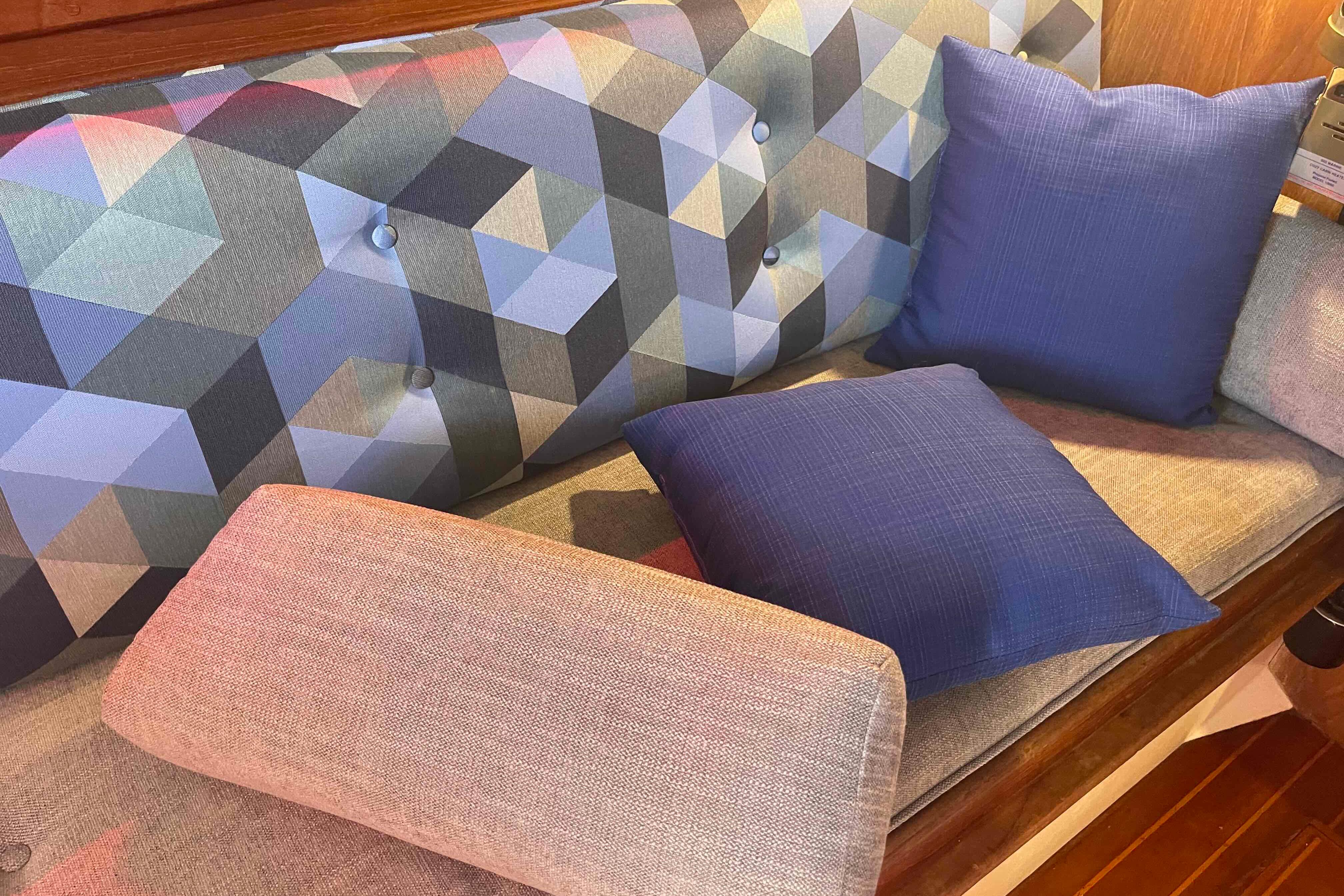 Geometric-patterned upholstery with blue cushions on a 1987 Pacific Seacraft 34 sailboat interior.