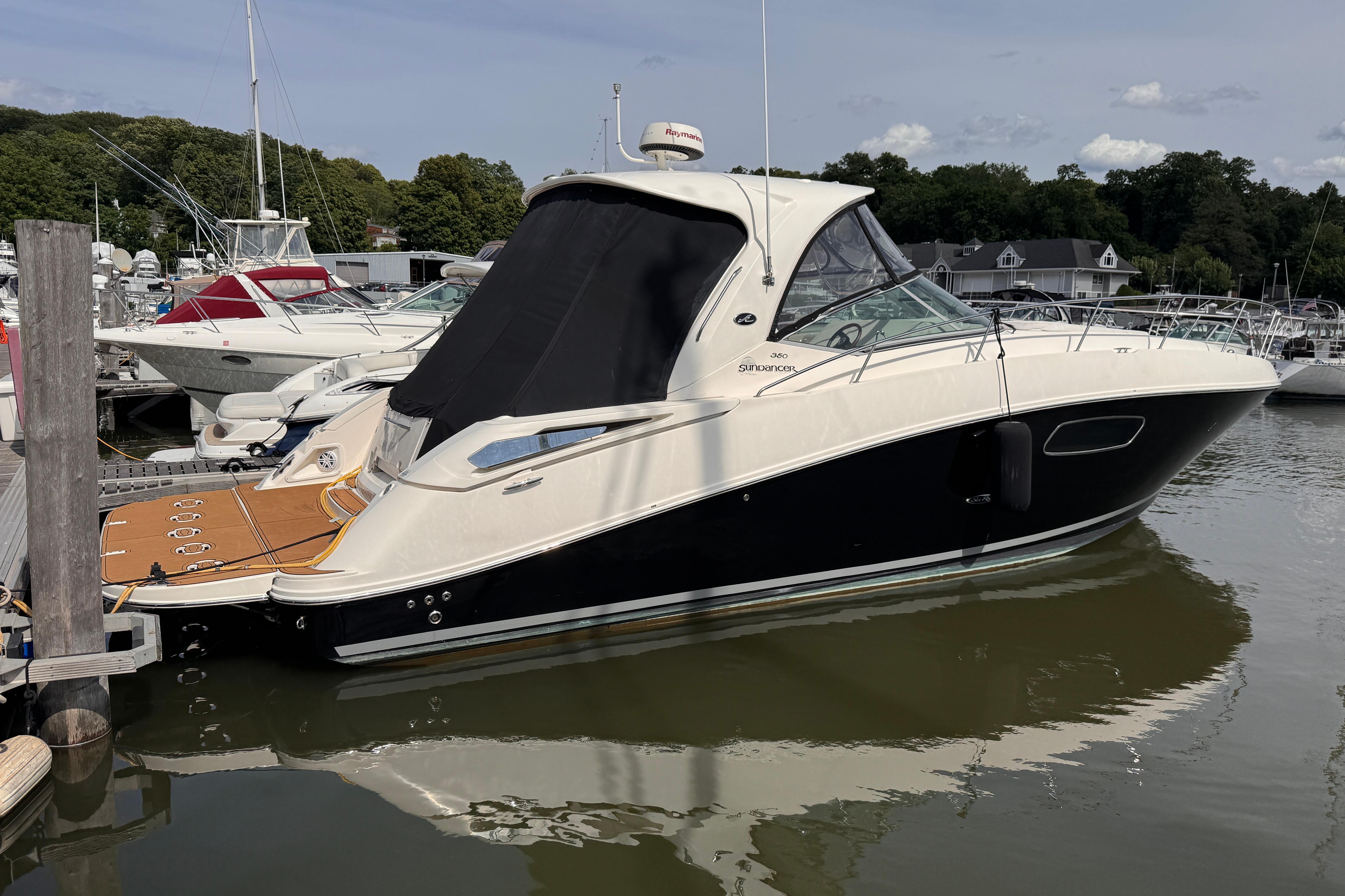 2008 Sea Ray Sundancer 350 yacht docked at marina, featuring sleek design and black hull.
