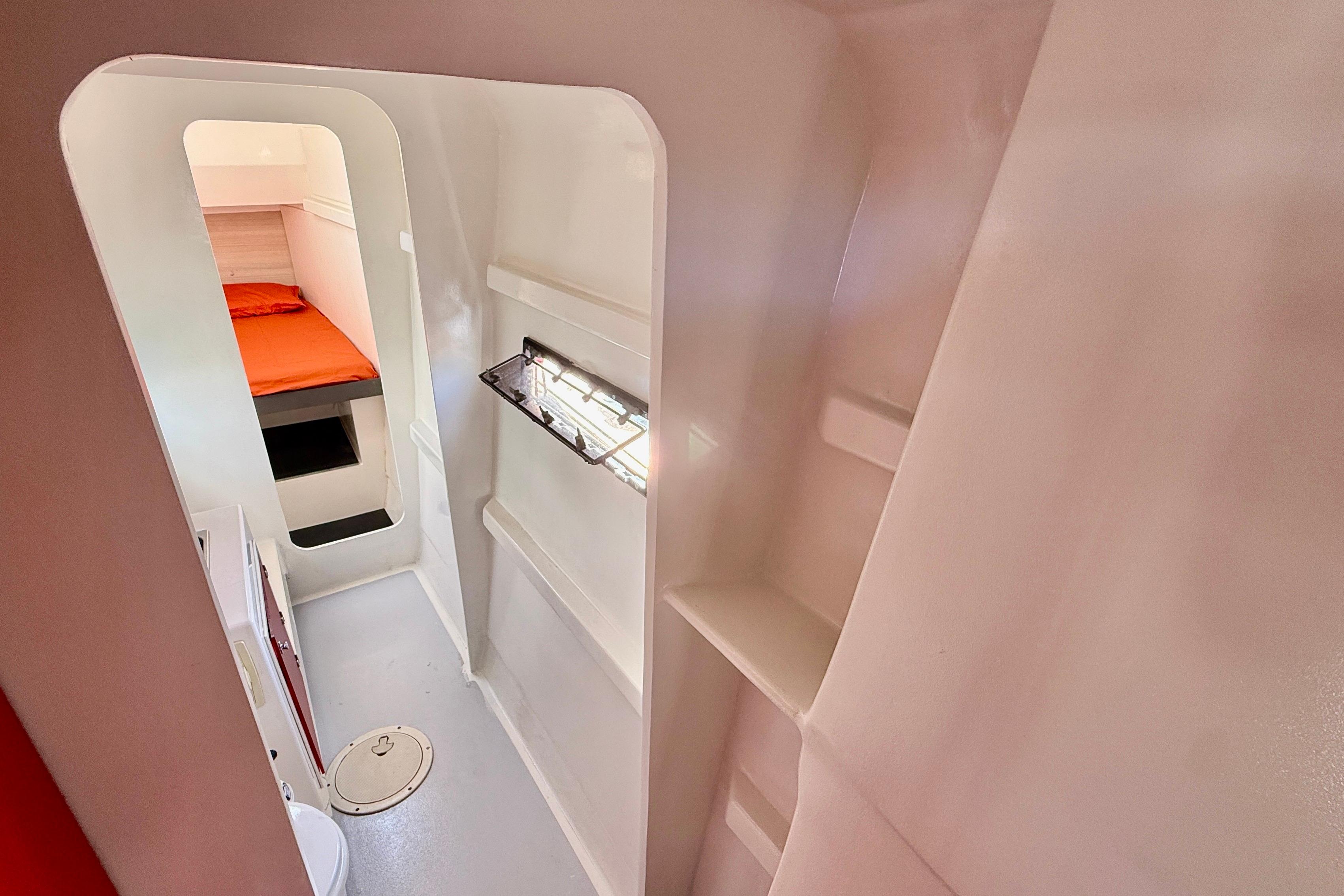 Interior of 2014 Marsaudon Composites ORC 42 yacht, featuring a compact cabin with orange bedding.