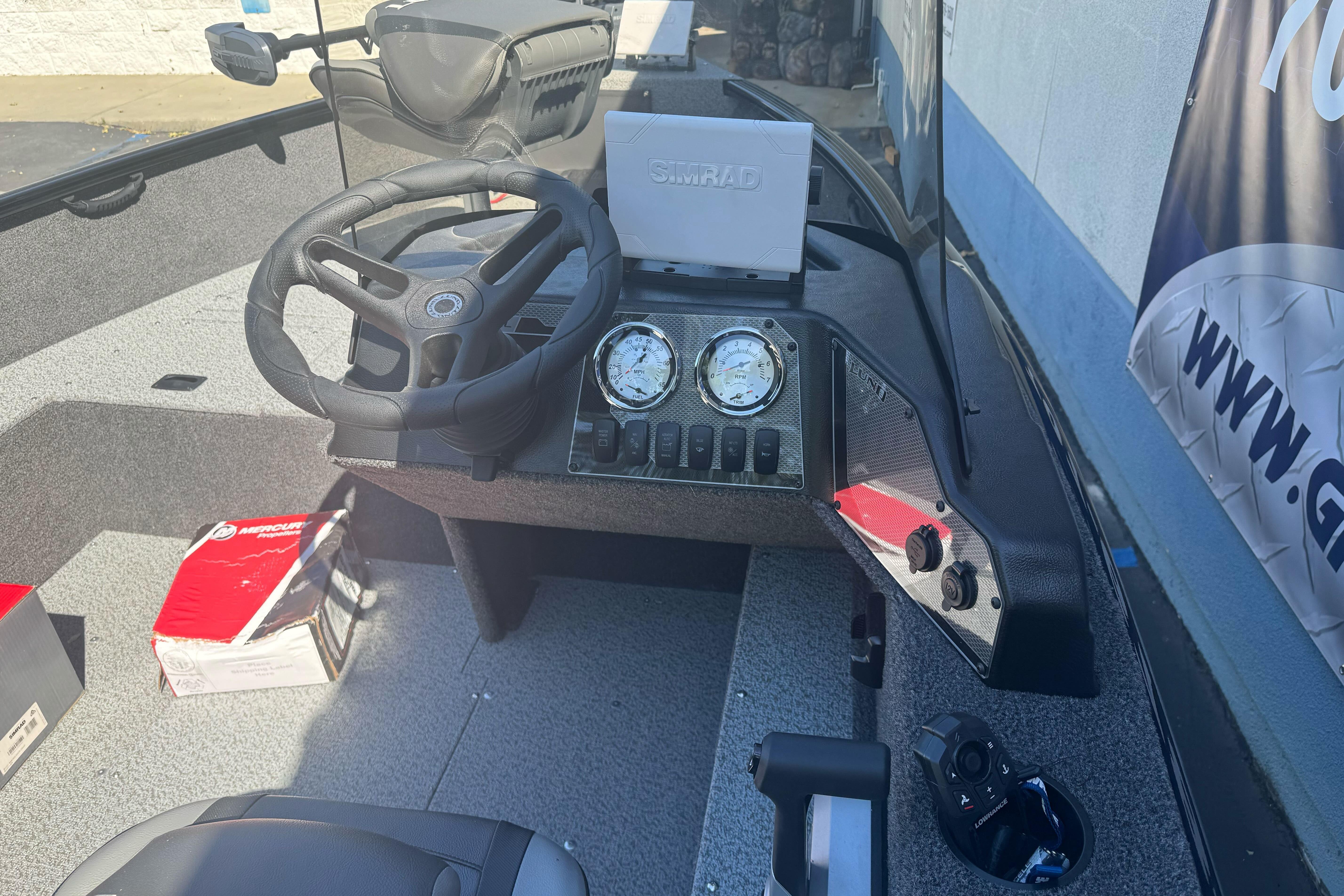 2026 Lund 1650 Rebel XL SS boat dashboard with steering wheel and Simrad display.