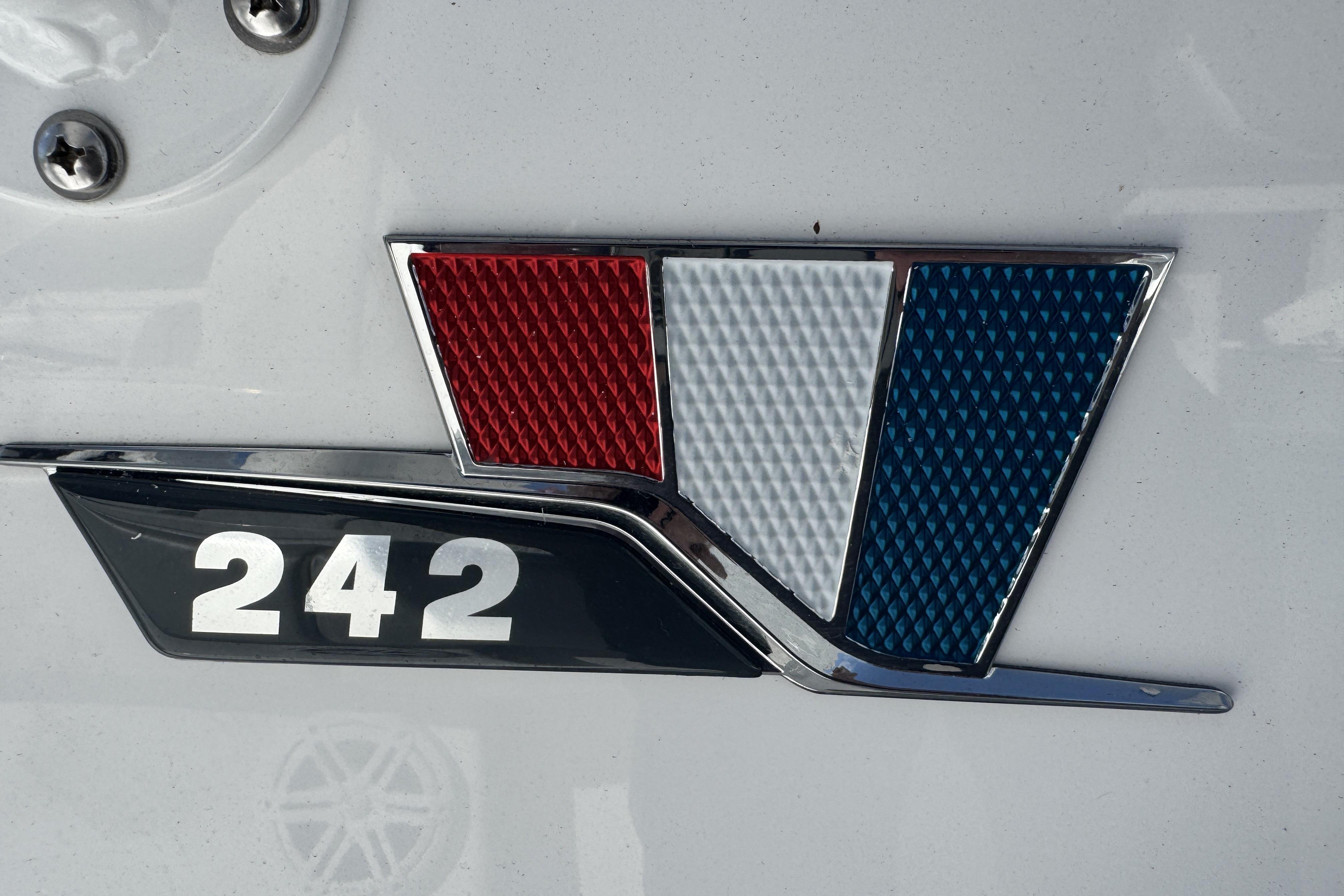 2025 Wellcraft 242 Fisherman emblem with red, white, and blue design.