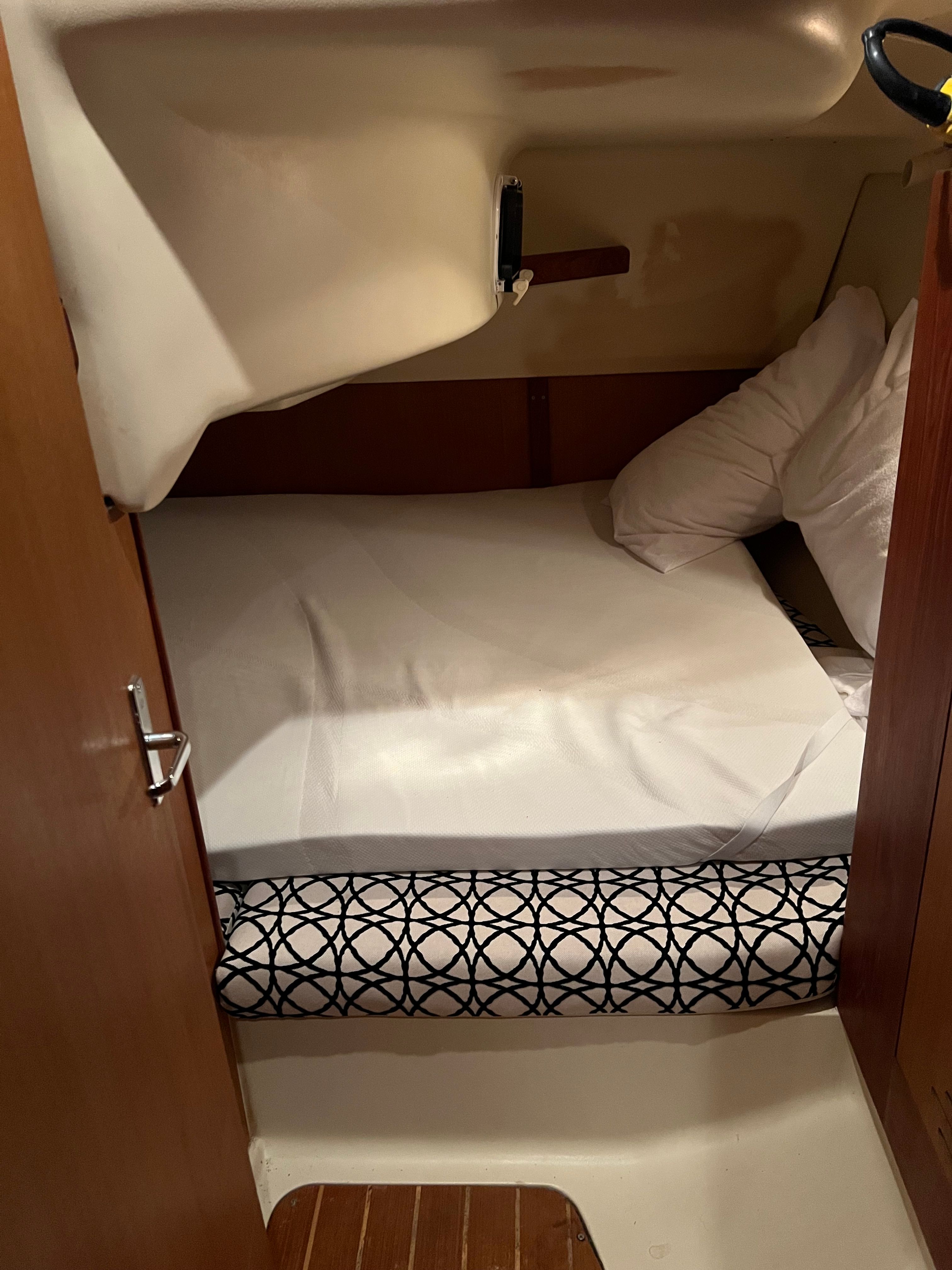 Small cabin with a bed and pillows inside a boat.