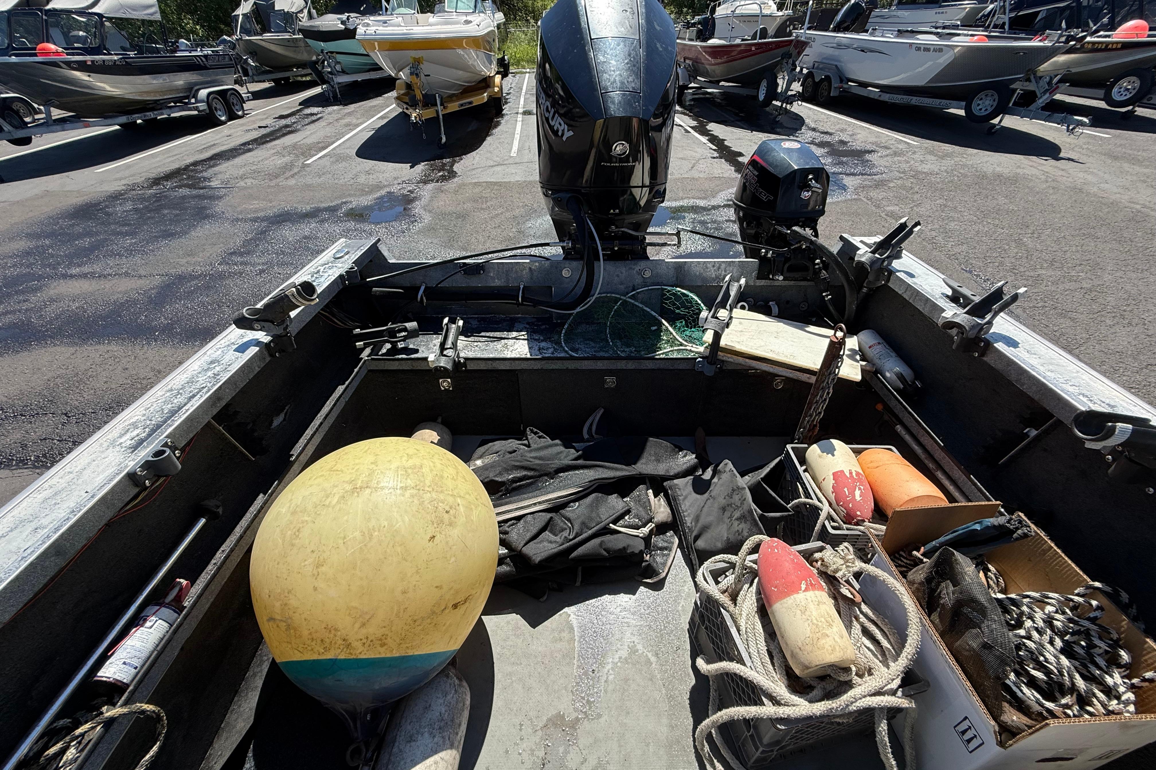 2004 Alumaweld Intruder Outboard 20 boat interior with fishing gear and equipment.