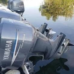 Two Yamaha outboard motors on a boat in calm water.