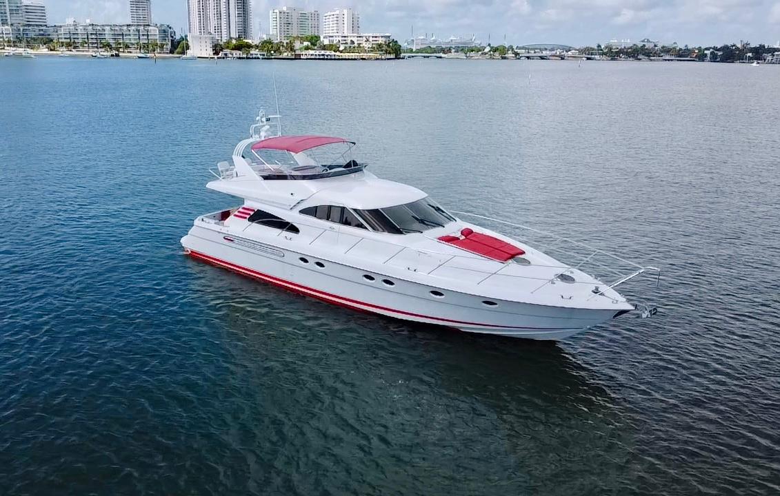 1999 Fairline Squadron 65 luxury yacht on calm waters with city skyline background.