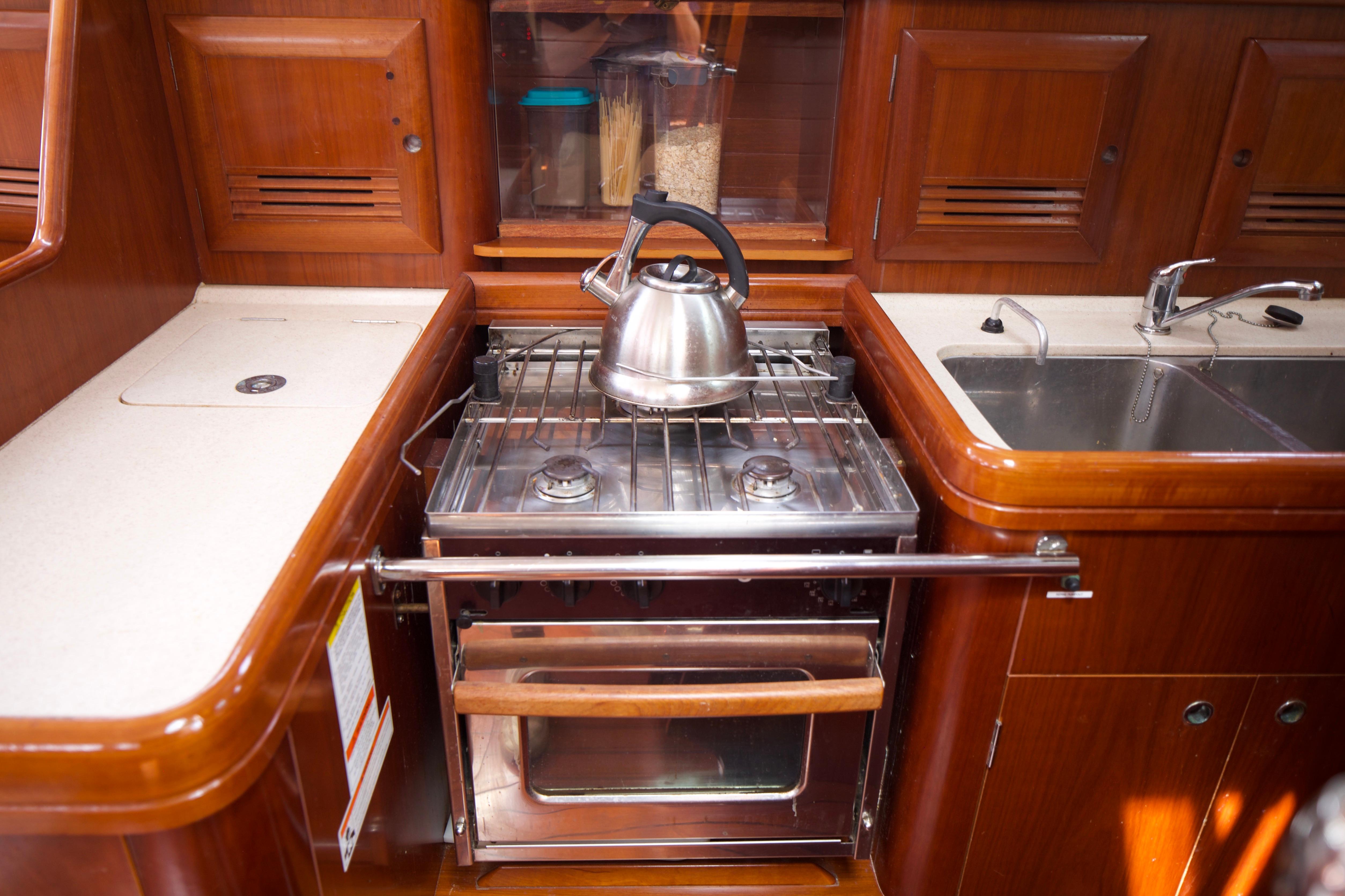 Galley kitchen in 2005 Beneteau 423 yacht with stove, kettle, and sink.