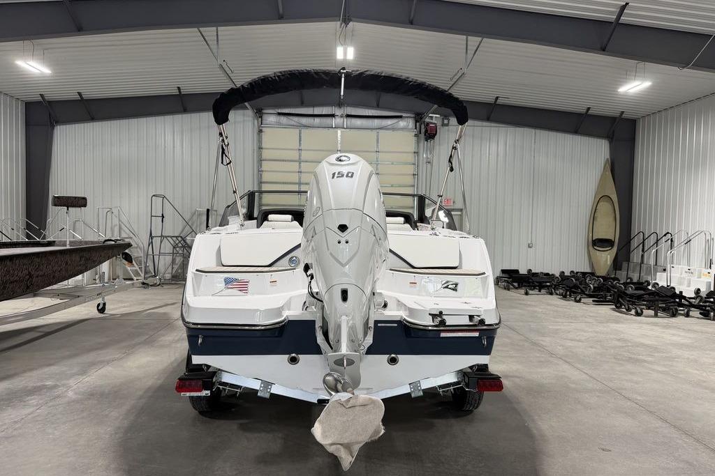 2027 Stingray 20 SBX boat with 150 HP engine in a storage facility.