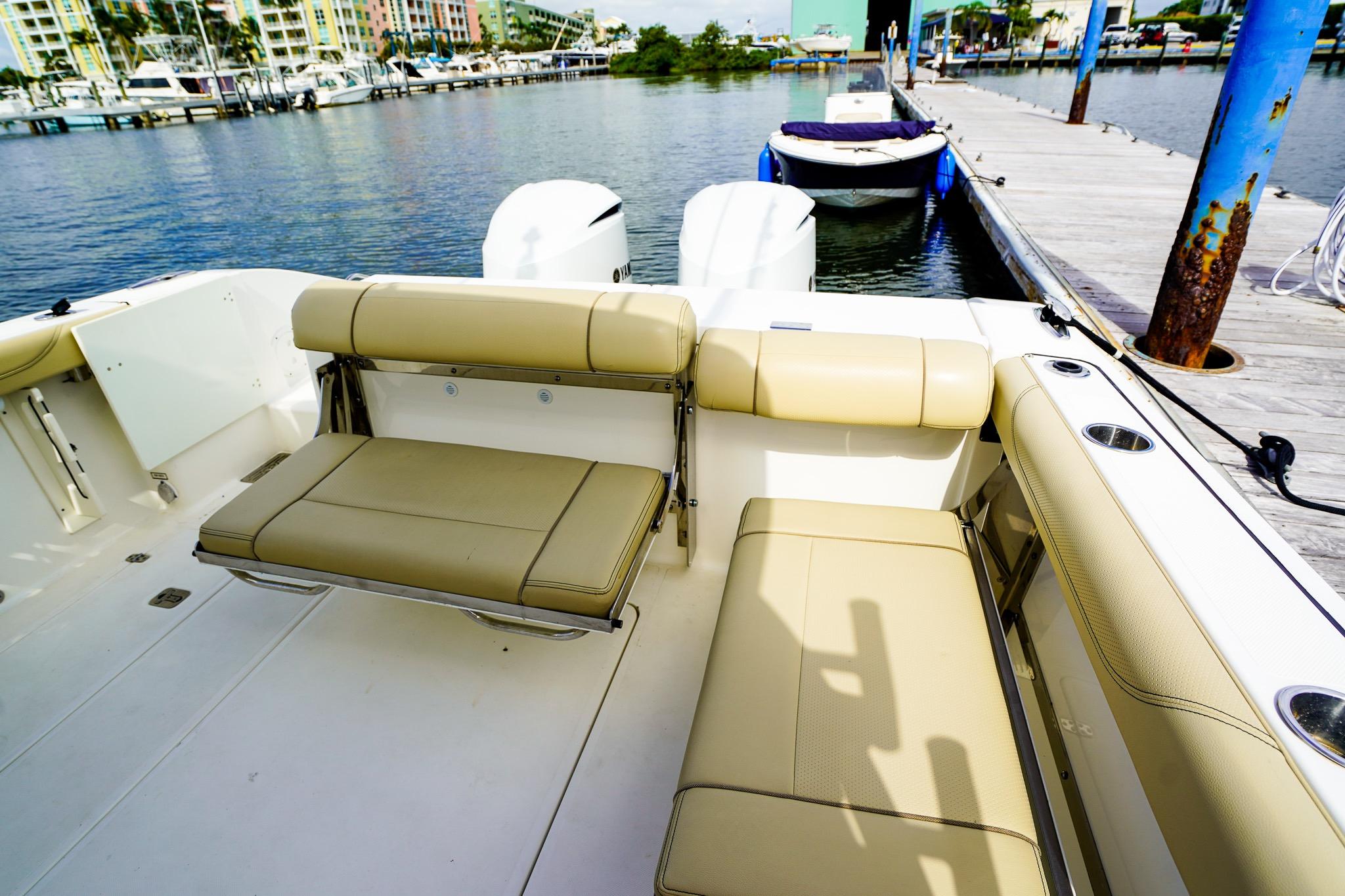 2020 Pursuit OS 325 Offshore boat interior with beige seating at marina dock.