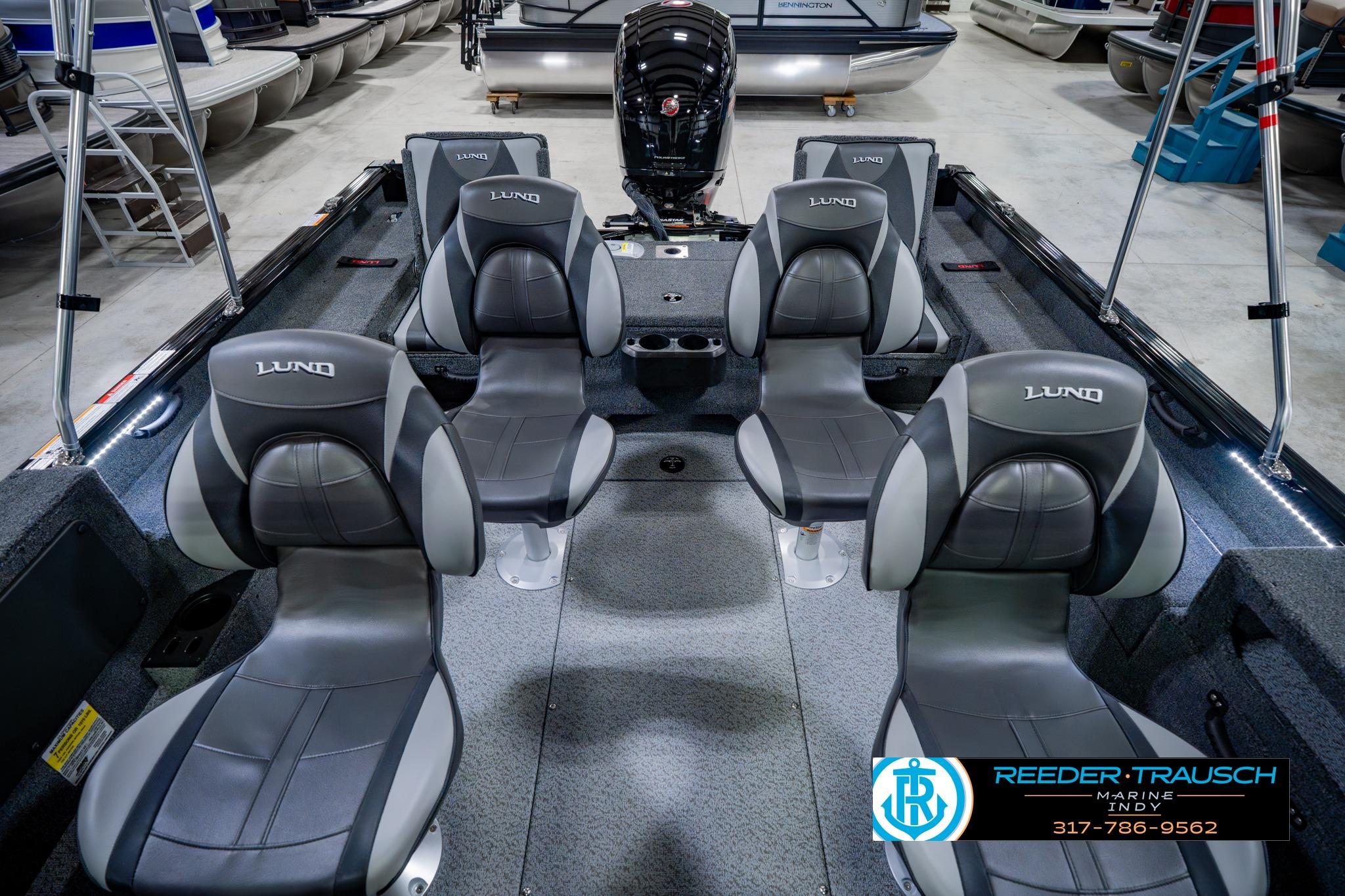 2026 Lund 1875 Impact XS boat interior with four gray seats in showroom.