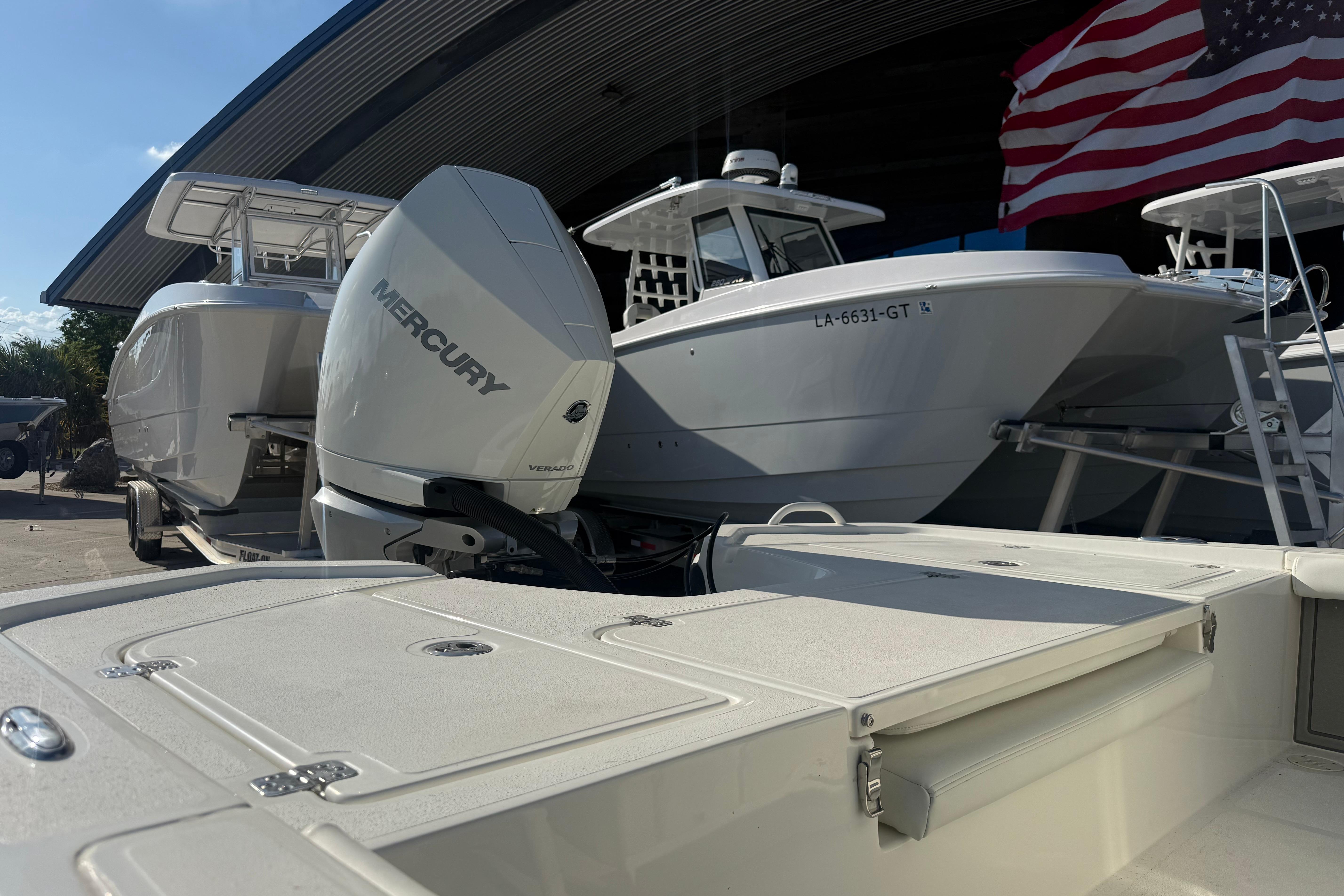 2026 Mako 24 APEX boat with Mercury engine, docked near American flag.