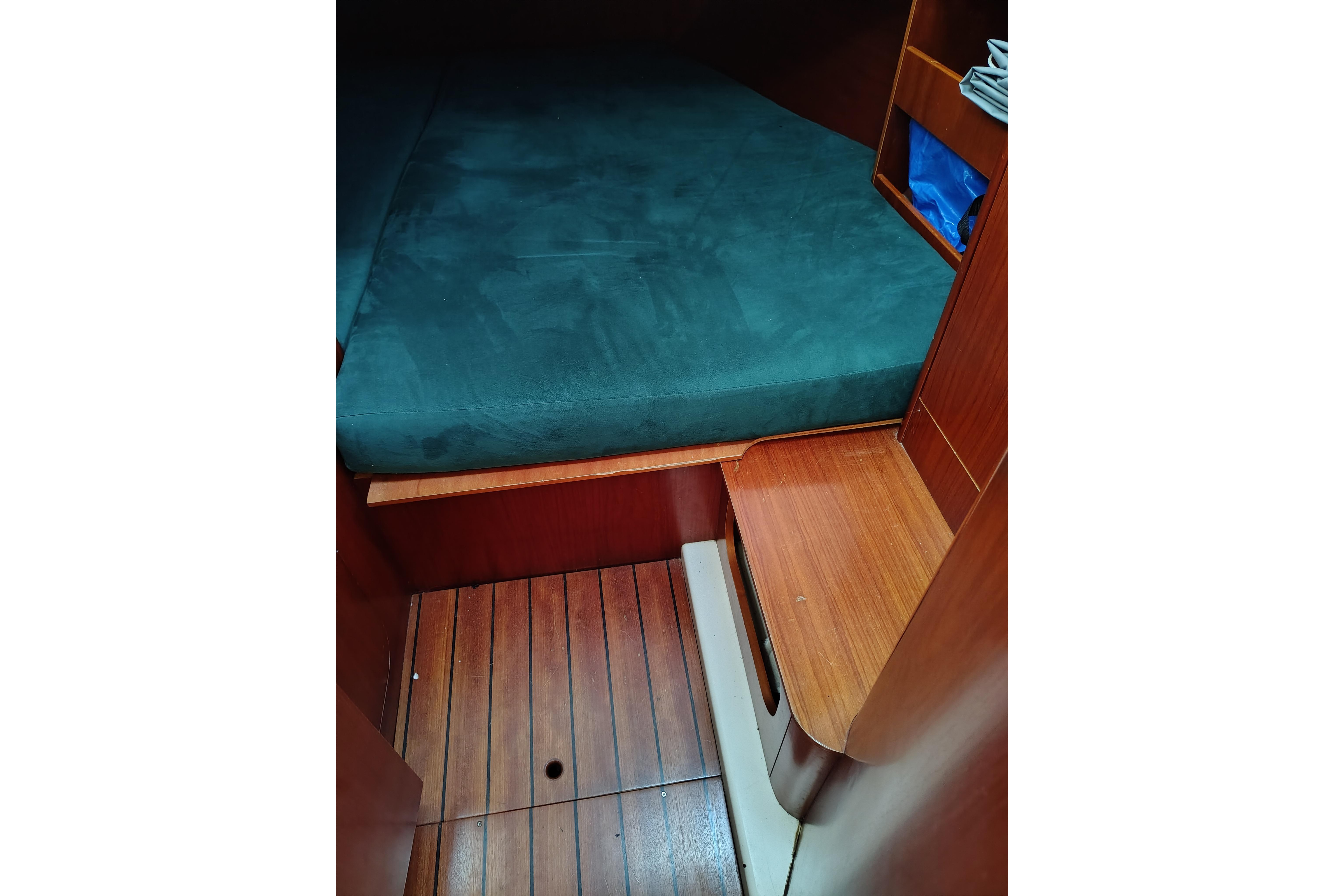 Interior cabin of 2001 Beneteau Oceanis 411 sailboat with wooden flooring and bed.