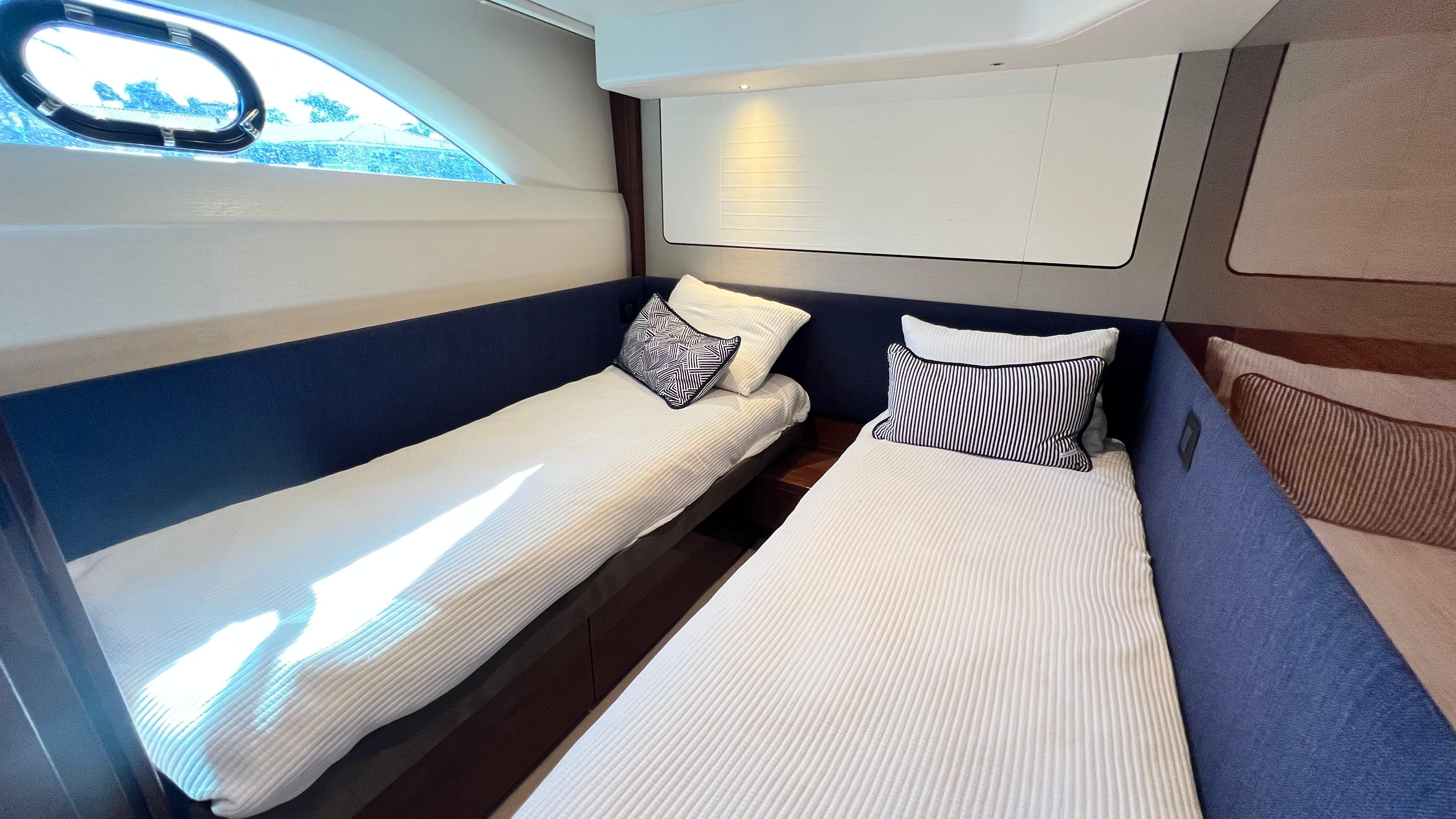 Luxurious twin cabin interior of 2019 Princess F62 yacht with elegant bedding.