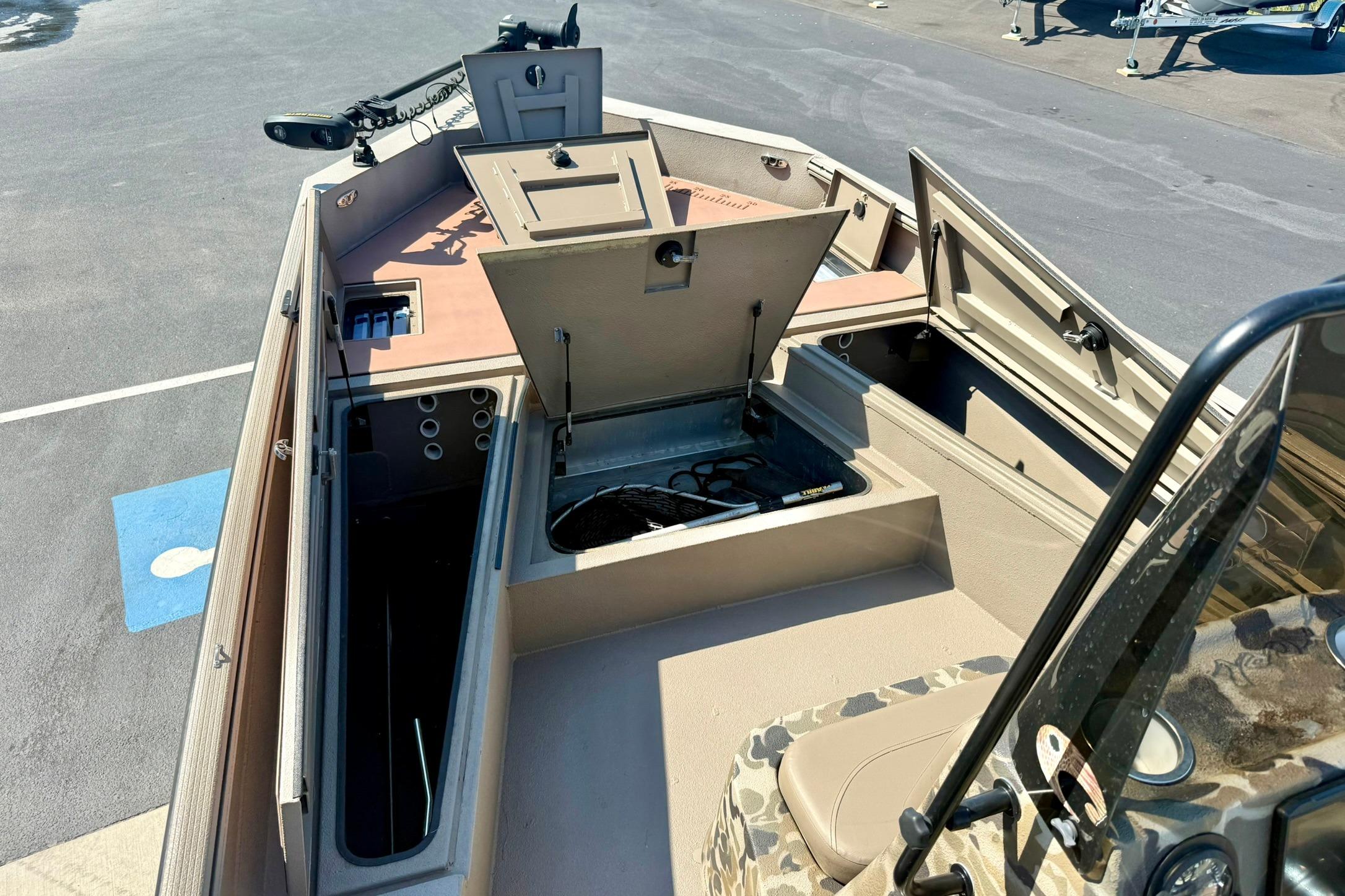 2019 Excel 230 Bay Pro boat interior with open storage compartments and camouflage seating.