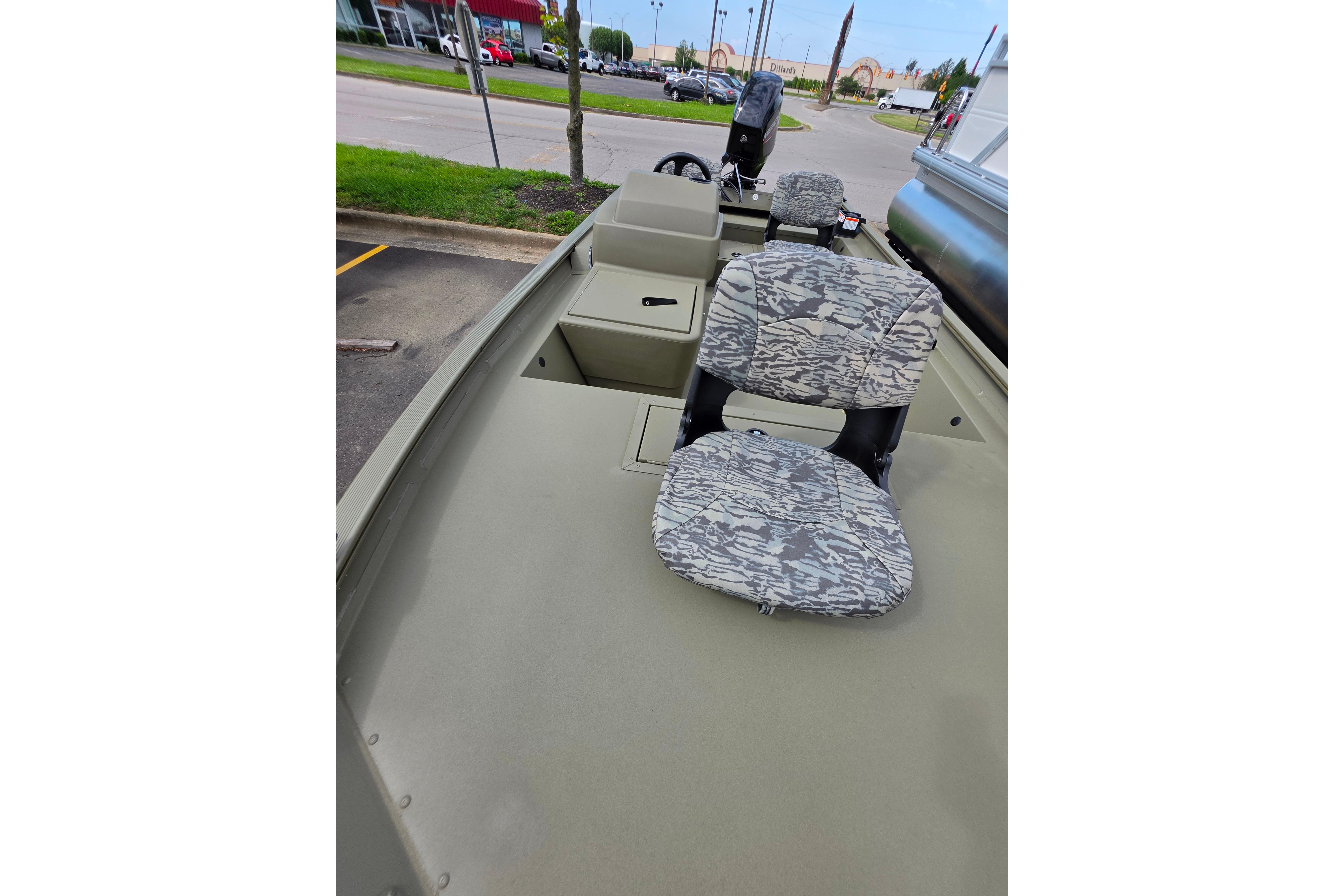 2026 Tracker Grizzly 1754 SC boat with camo seats, parked outdoors.