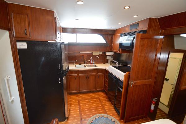 Interior of a 1980 Hatteras 53 Yacht Fisherman with wood cabinetry and modern kitchen.