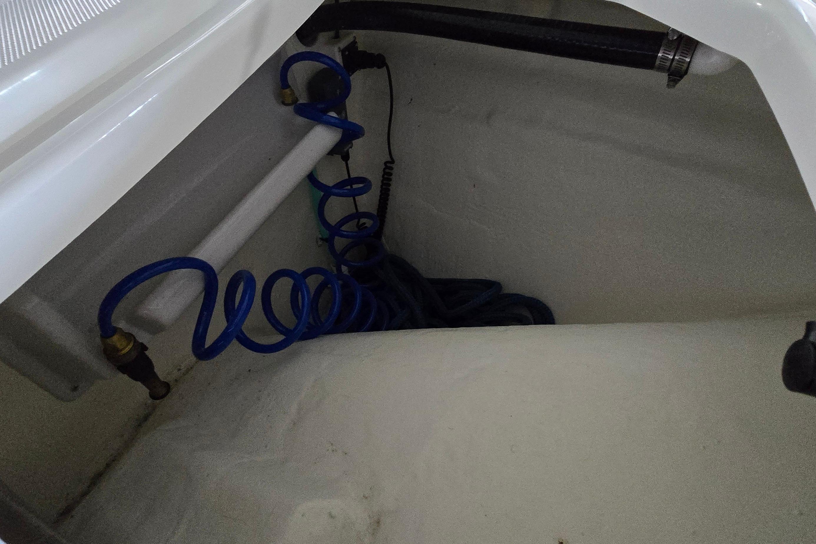 2024 WorldCat 280 CC-X boat interior with coiled blue hose and fittings.