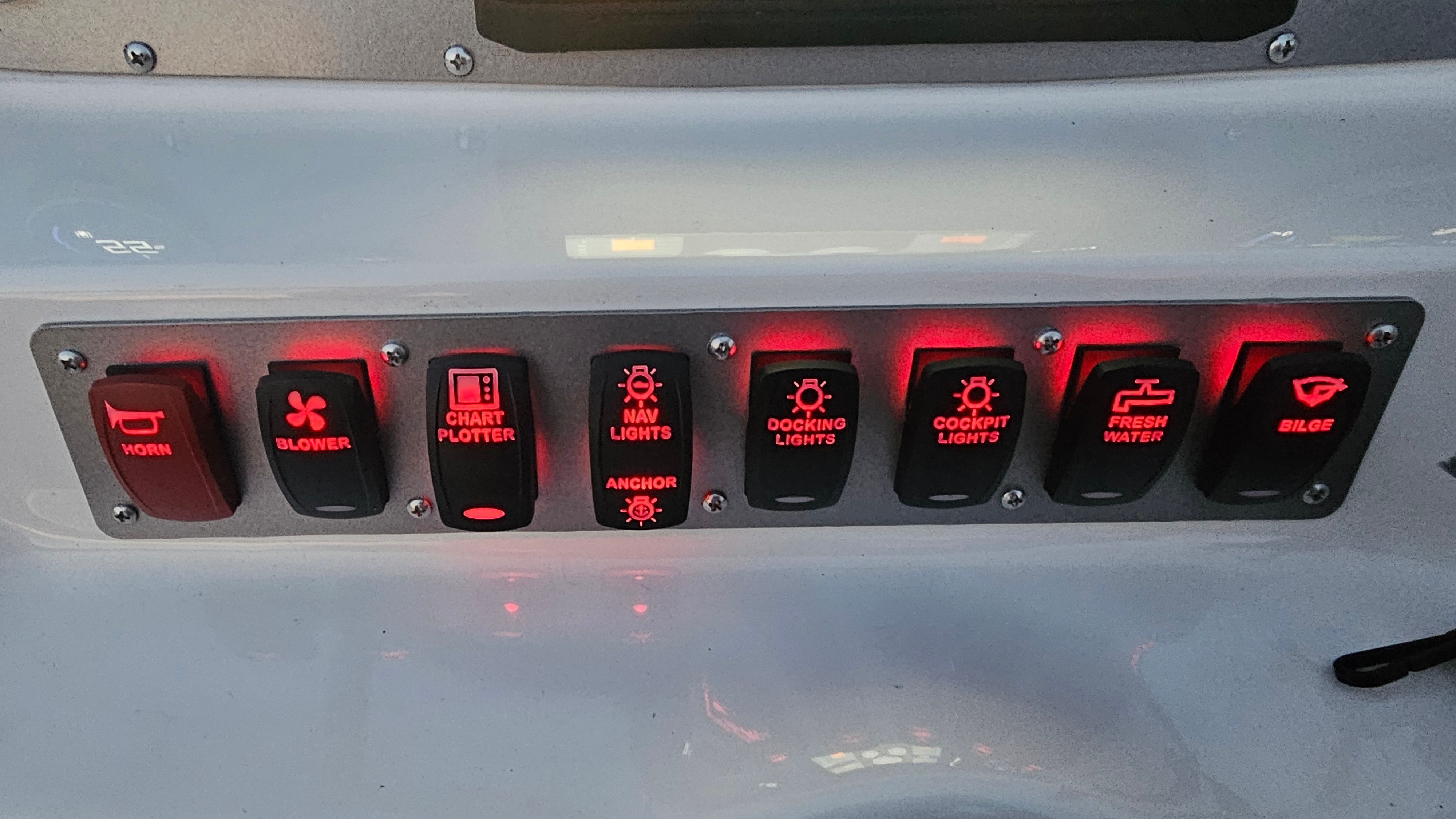 Illuminated switch panel on a boat dashboard.