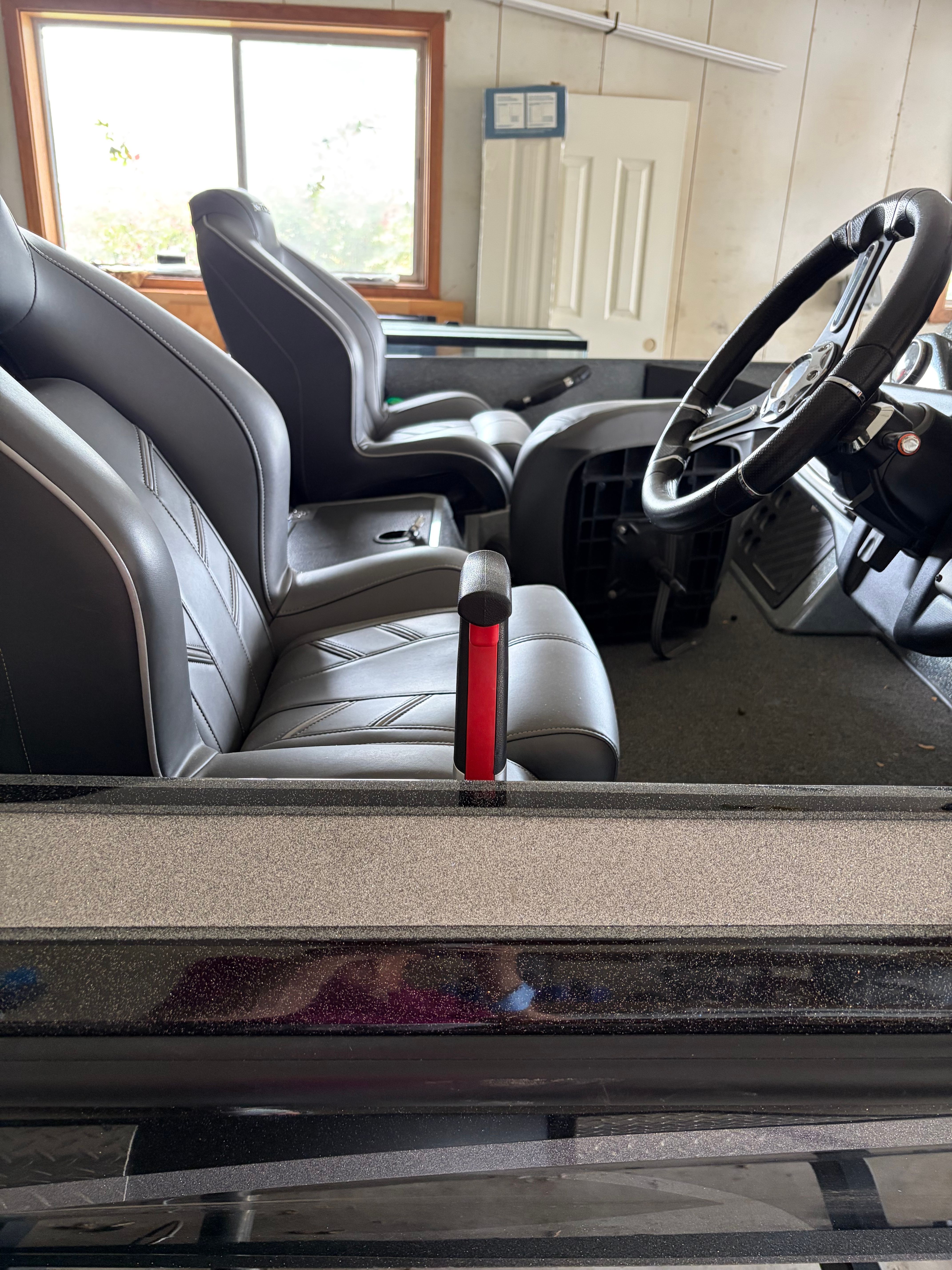 Interior view of a 2020 Nitro BASS boat with black seats and a steering wheel.