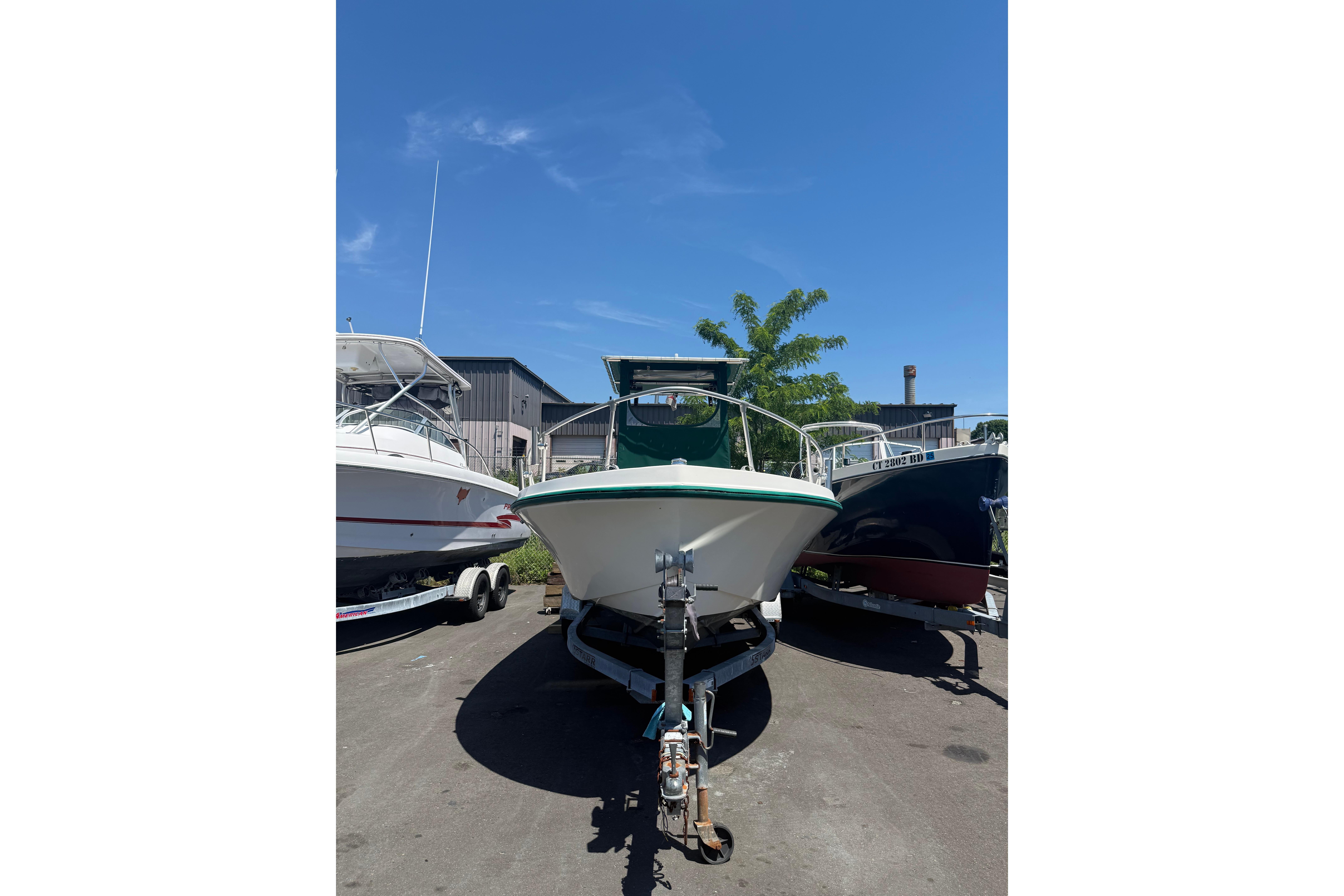 1982 Mako 20 Center Console boat on trailer under clear blue sky.