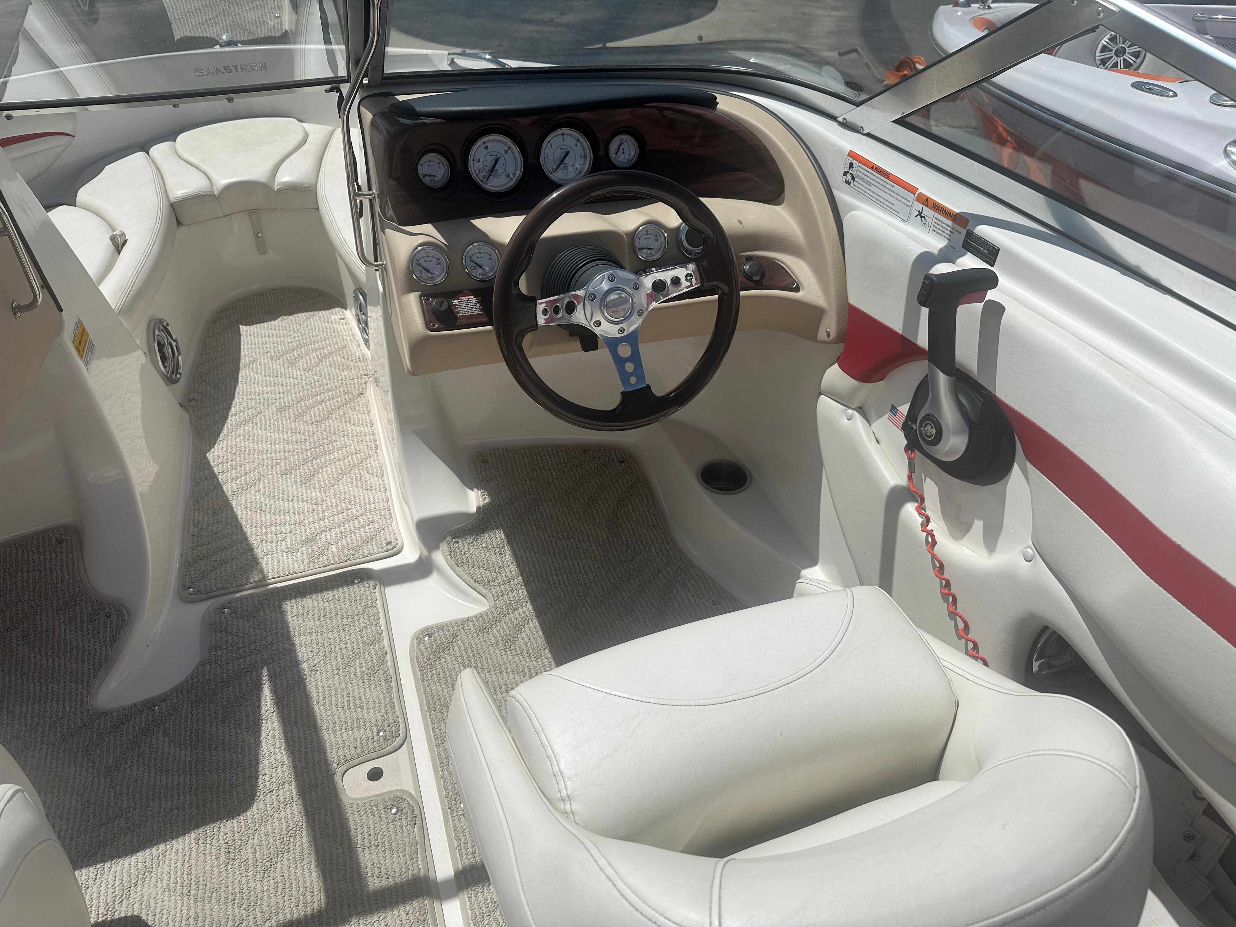Interior of a 2008 Glastron 205 GX boat, featuring steering wheel and dashboard controls.