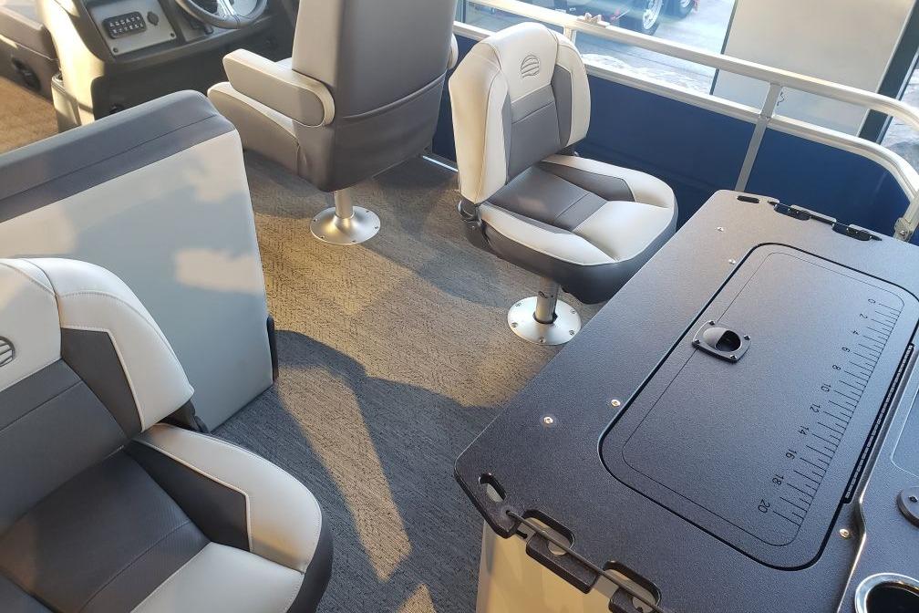 Interior of 2026 Sun Tracker Fishin' Barge 20 DLX with comfortable seating and fishing table.