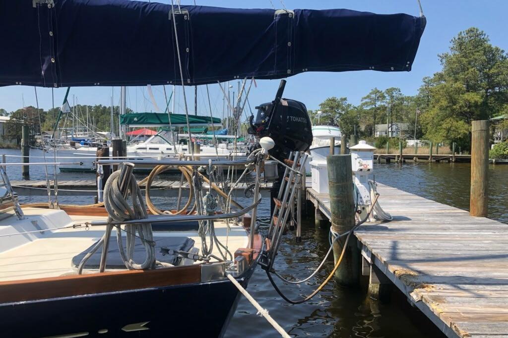 1984 Bristol 45.5 Center Cockpit sailboat docked at a marina with outboard motor.
