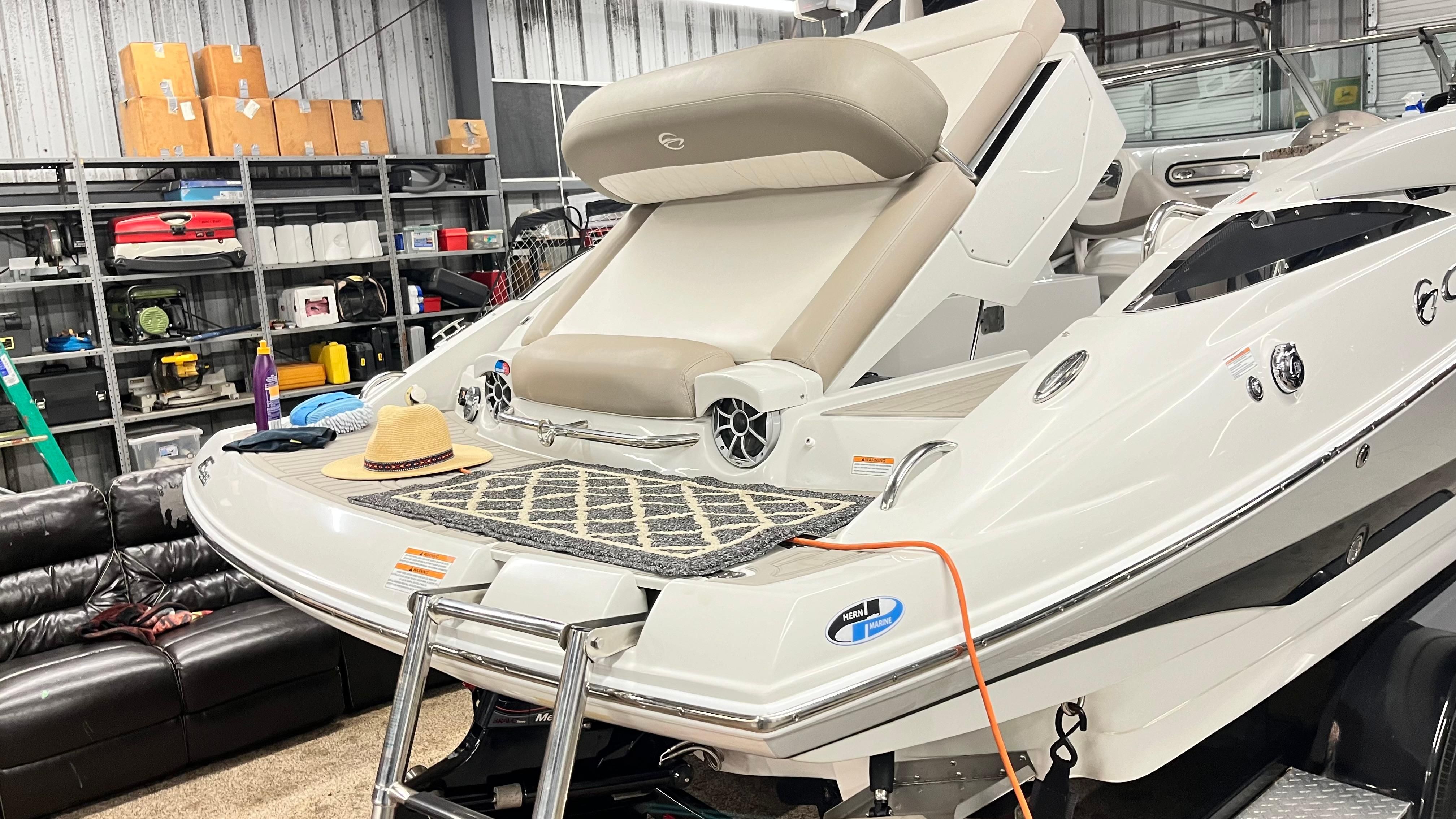 A 2019 Crownline E 285 boat in a storage facility. It features a beige lounging area.