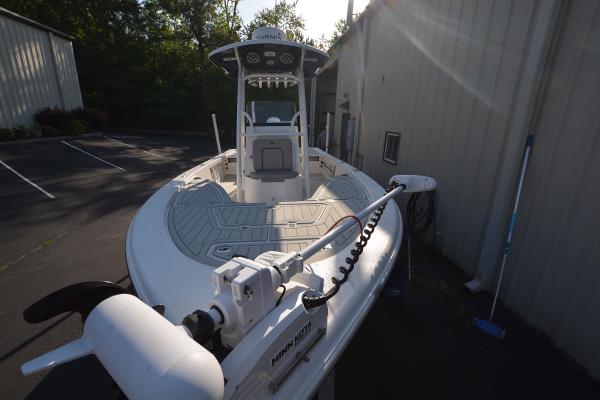 2021 Sea Pro 228 Bay boat with trolling motor, parked outdoors near a building.