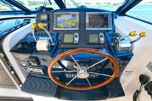 Helm of 2008 Tiara Yachts 4200 Open with navigation screens and wooden steering wheel.