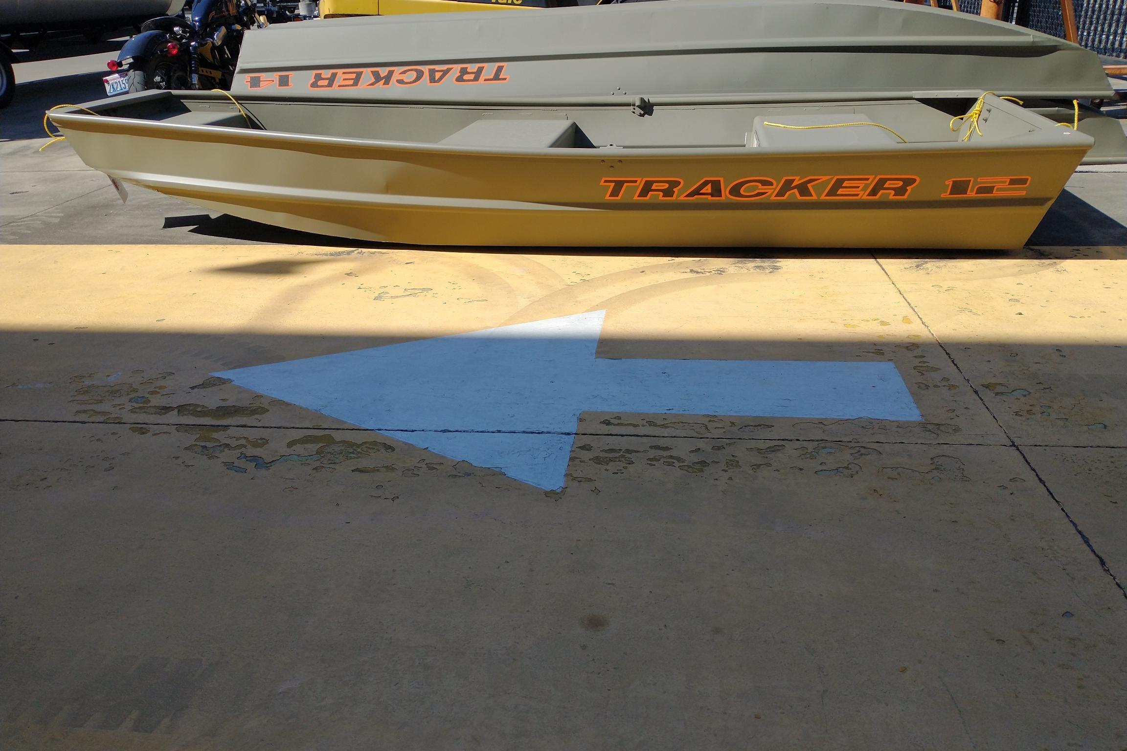 2026 Tracker Grizzly 12 Jon boat on concrete with directional arrow.