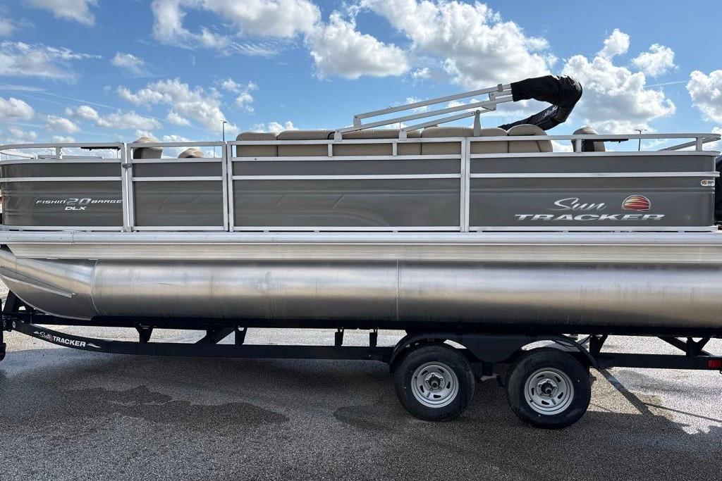 2025 Sun Tracker Fishin' Barge 20 DLX pontoon boat on trailer under blue sky.