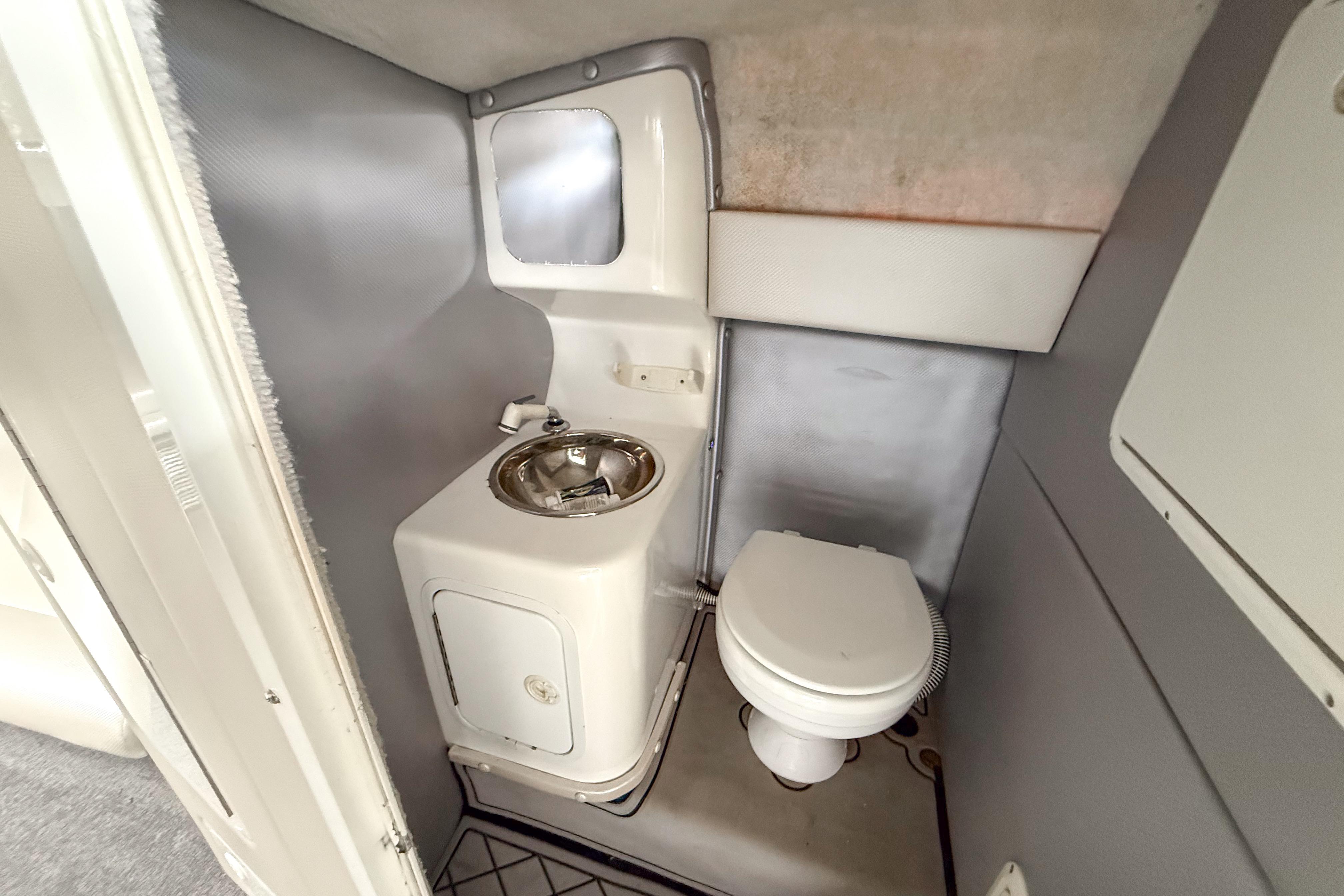 Compact bathroom in a 2002 Active Thunder 37 boat, featuring a toilet and sink.
