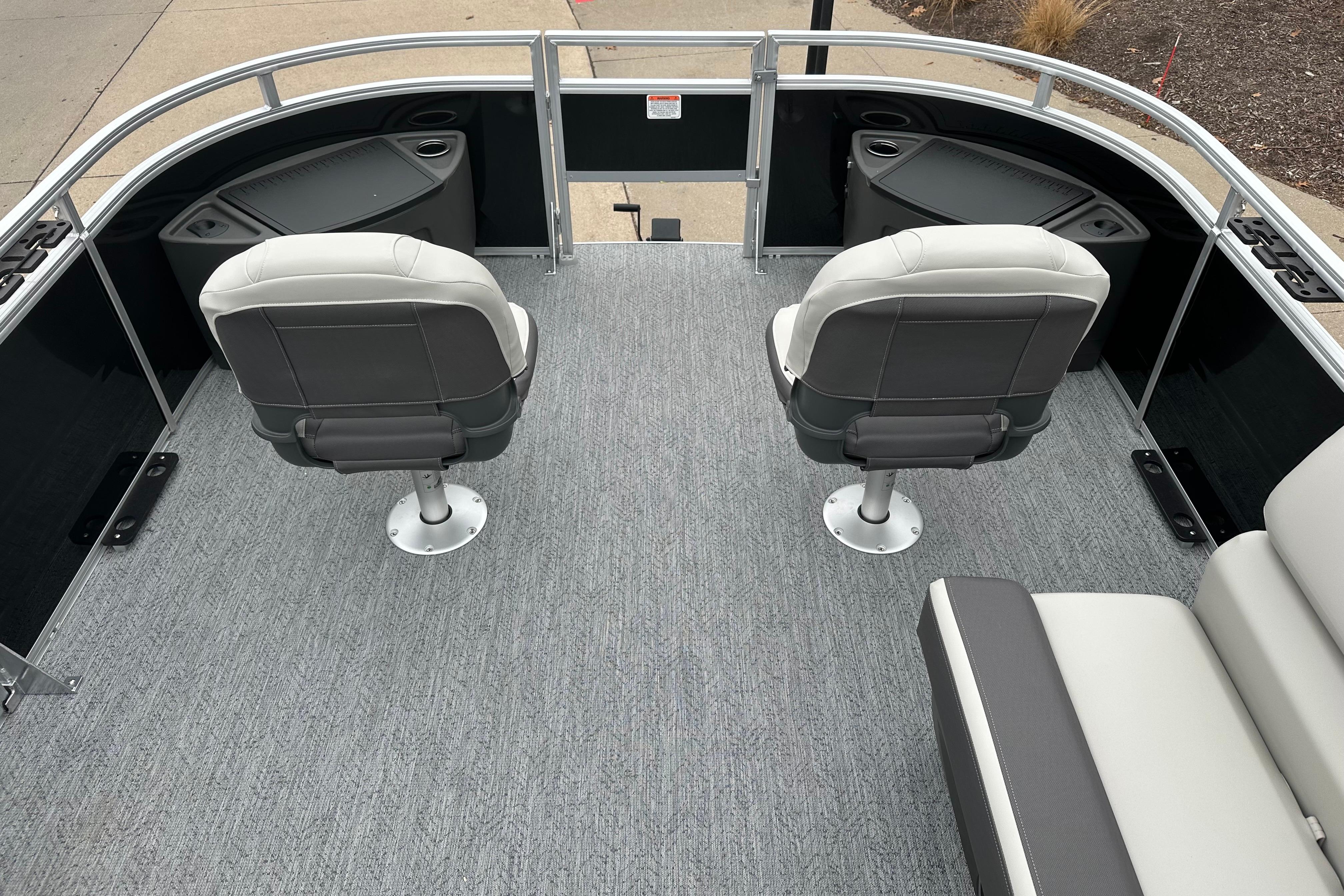 2026 Sun Tracker Fishin' Barge 22 DLX interior with two swivel seats and carpeted deck.