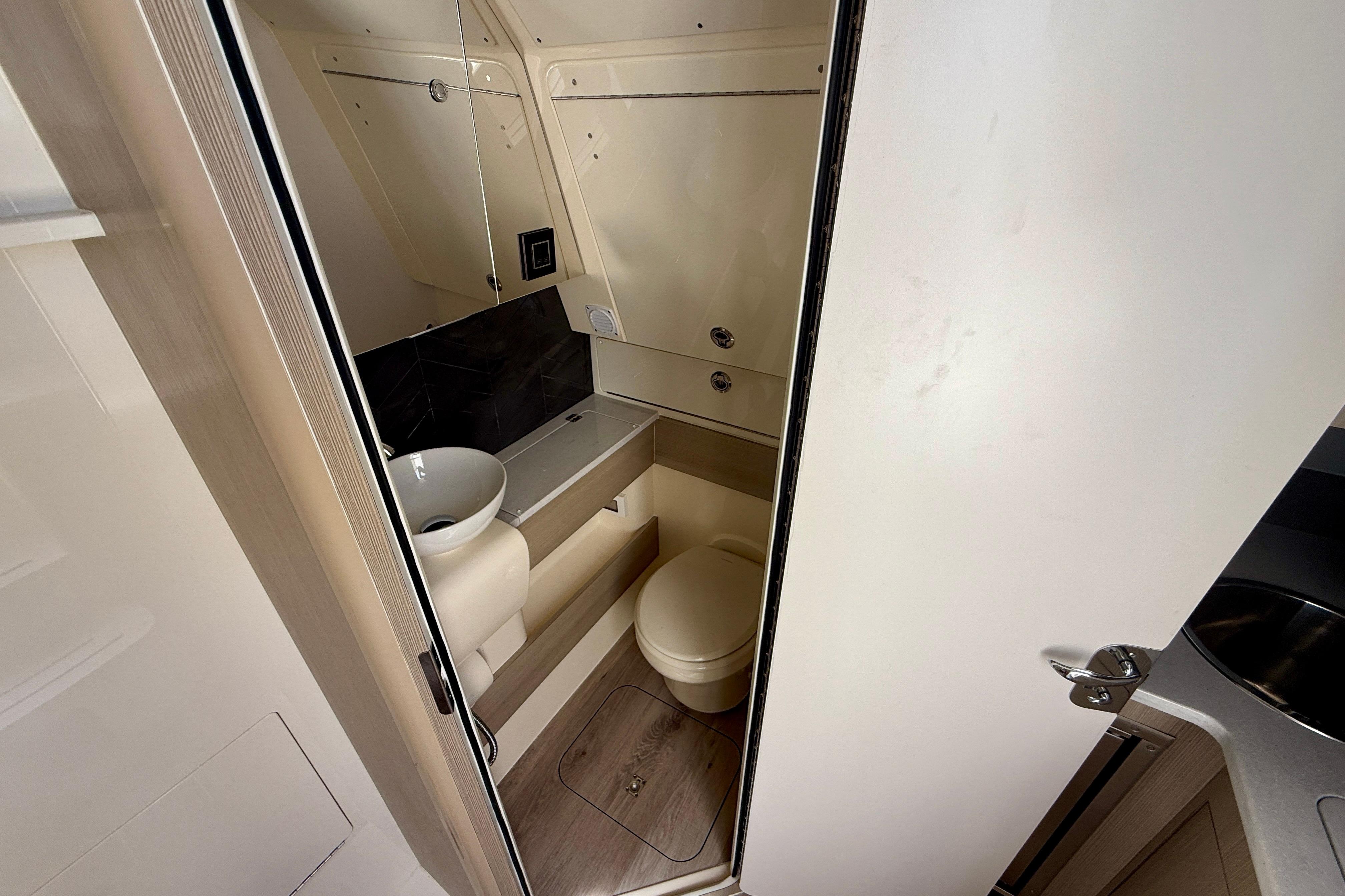 Compact bathroom interior of 2026 Scout 400 LXF Li-Ion boat, featuring modern fixtures.