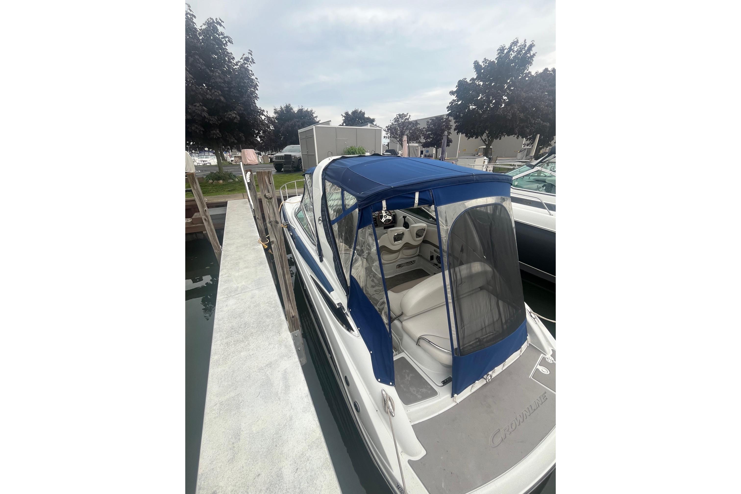 2016 Crownline 264 CR boat docked with blue canopy and white interior.