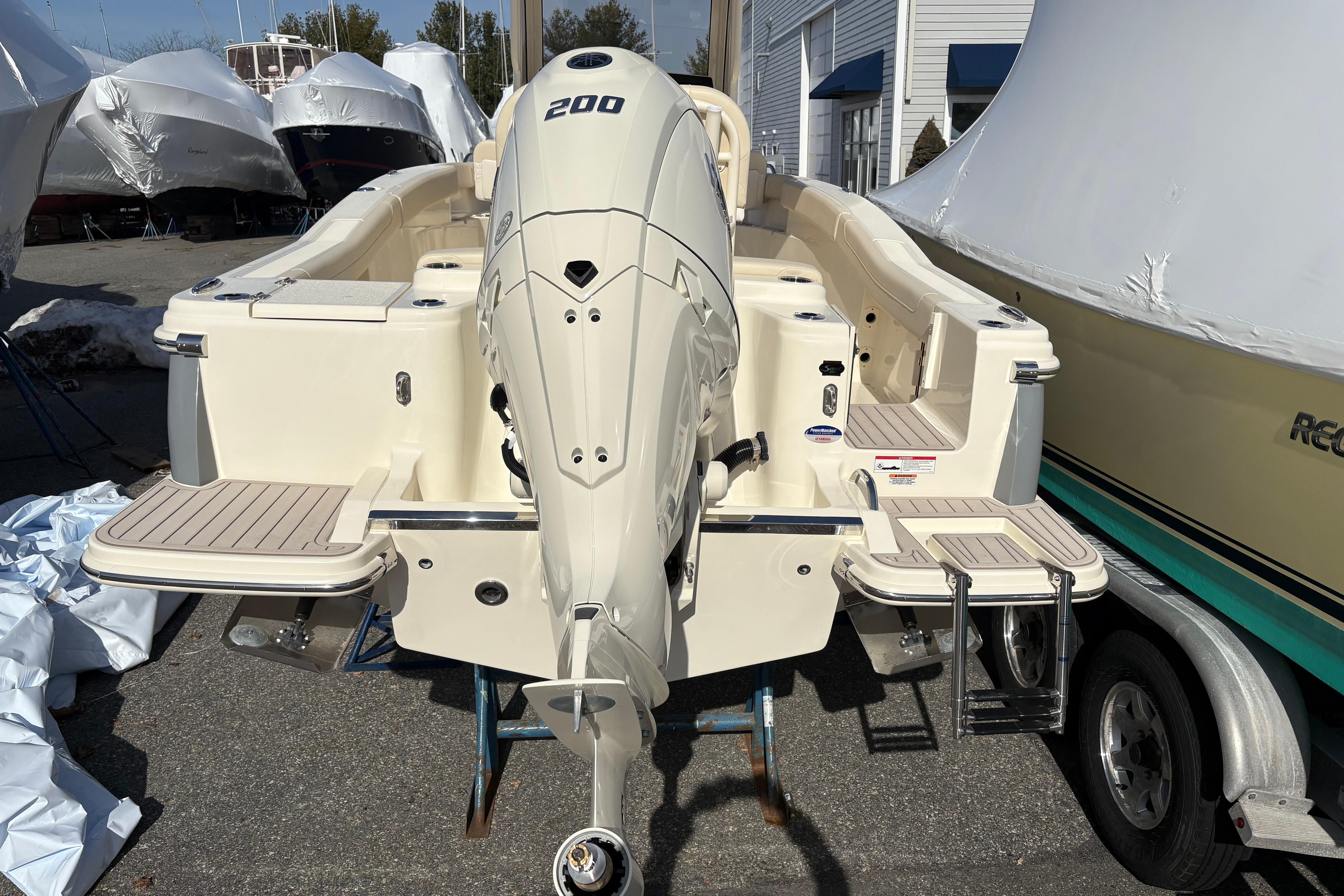 2026 Scout 220 XSF boat with powerful outboard motor, docked outdoors.