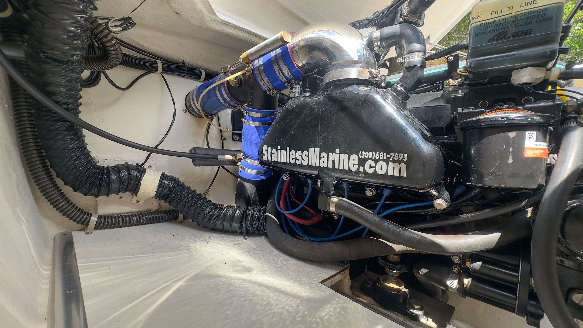 Boat engine compartment with visible hoses and engine components.