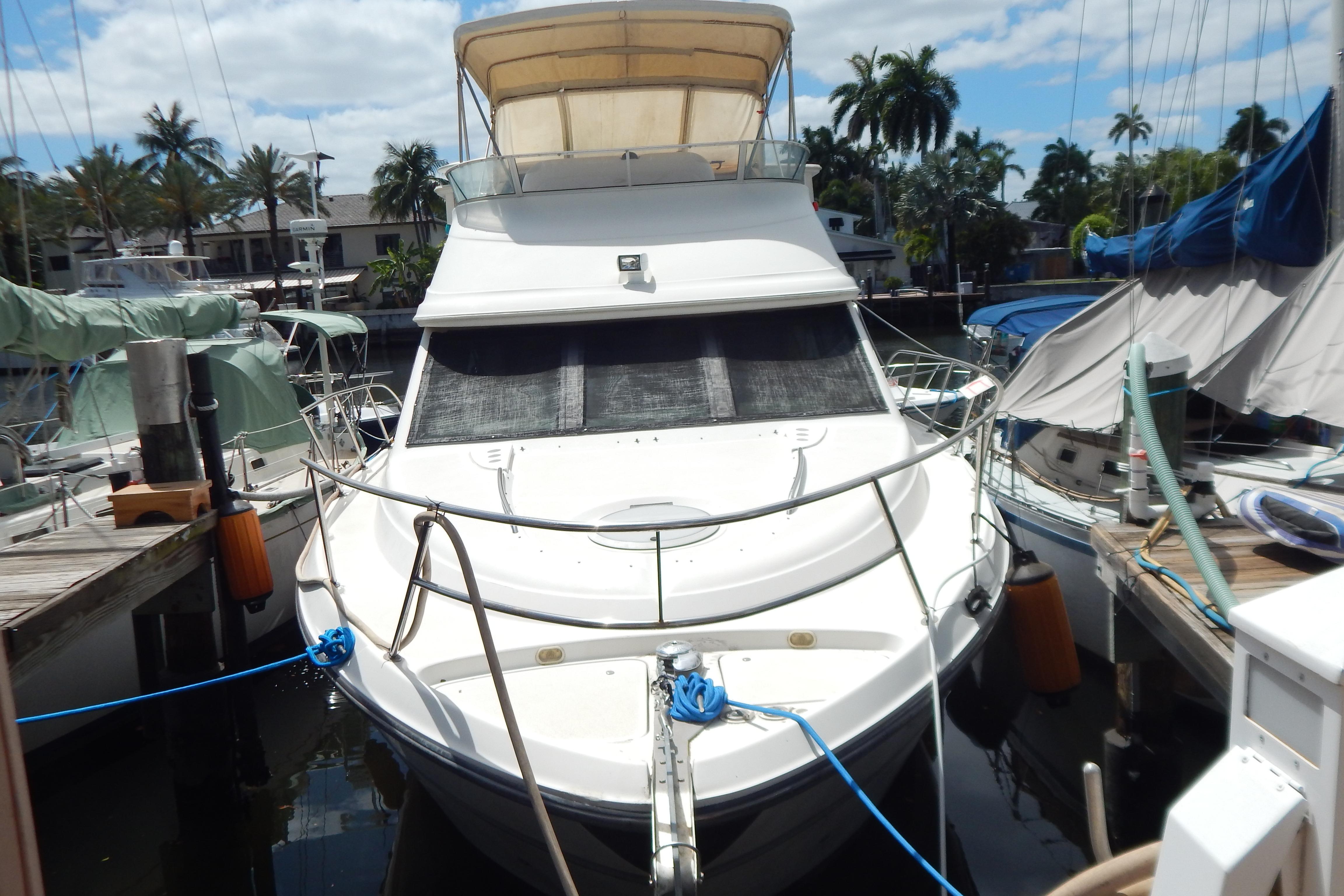 1998 Magnum 4100 SCR yacht docked at marina with palm trees in background.