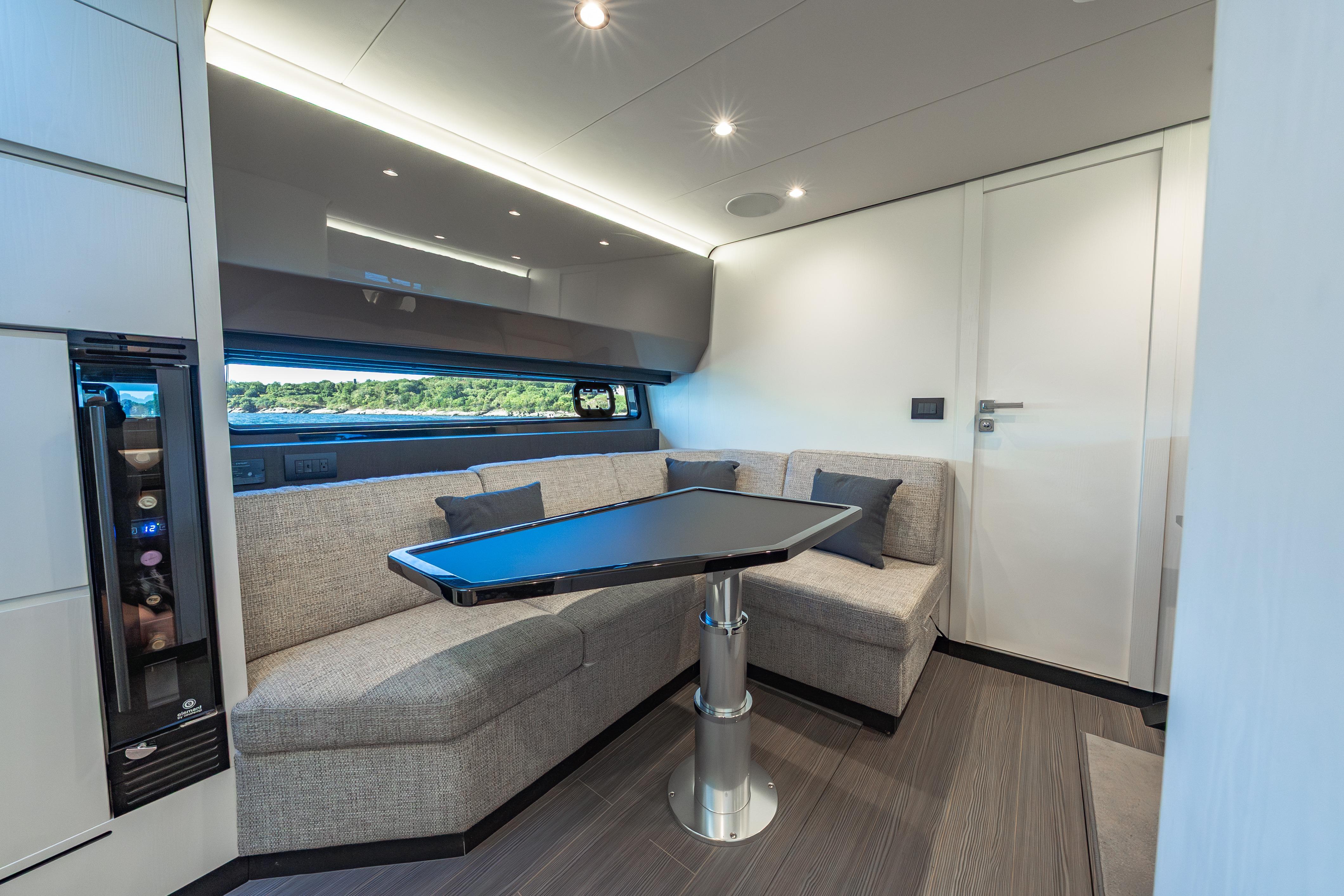 Luxurious interior of 2023 Azimut Verve 47 yacht with modern seating and sleek table design.