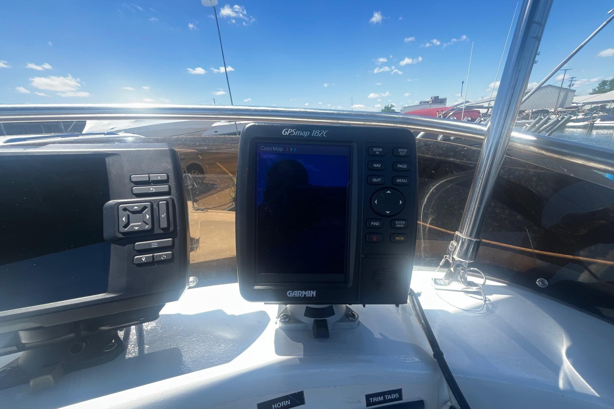 Garmin GPS device on 1988 Seafox 29 Flybridge boat under clear blue sky.