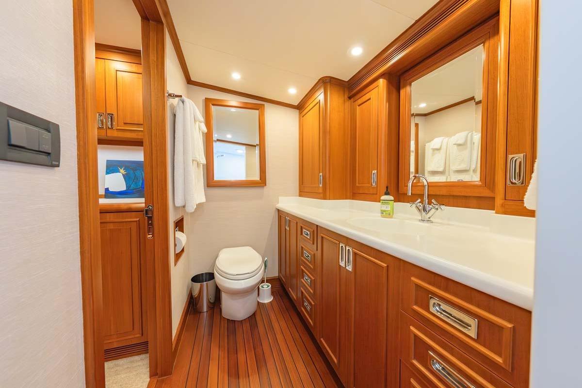 Luxurious 1984 Feadship Yacht Fish bathroom with wooden cabinetry and modern fixtures.