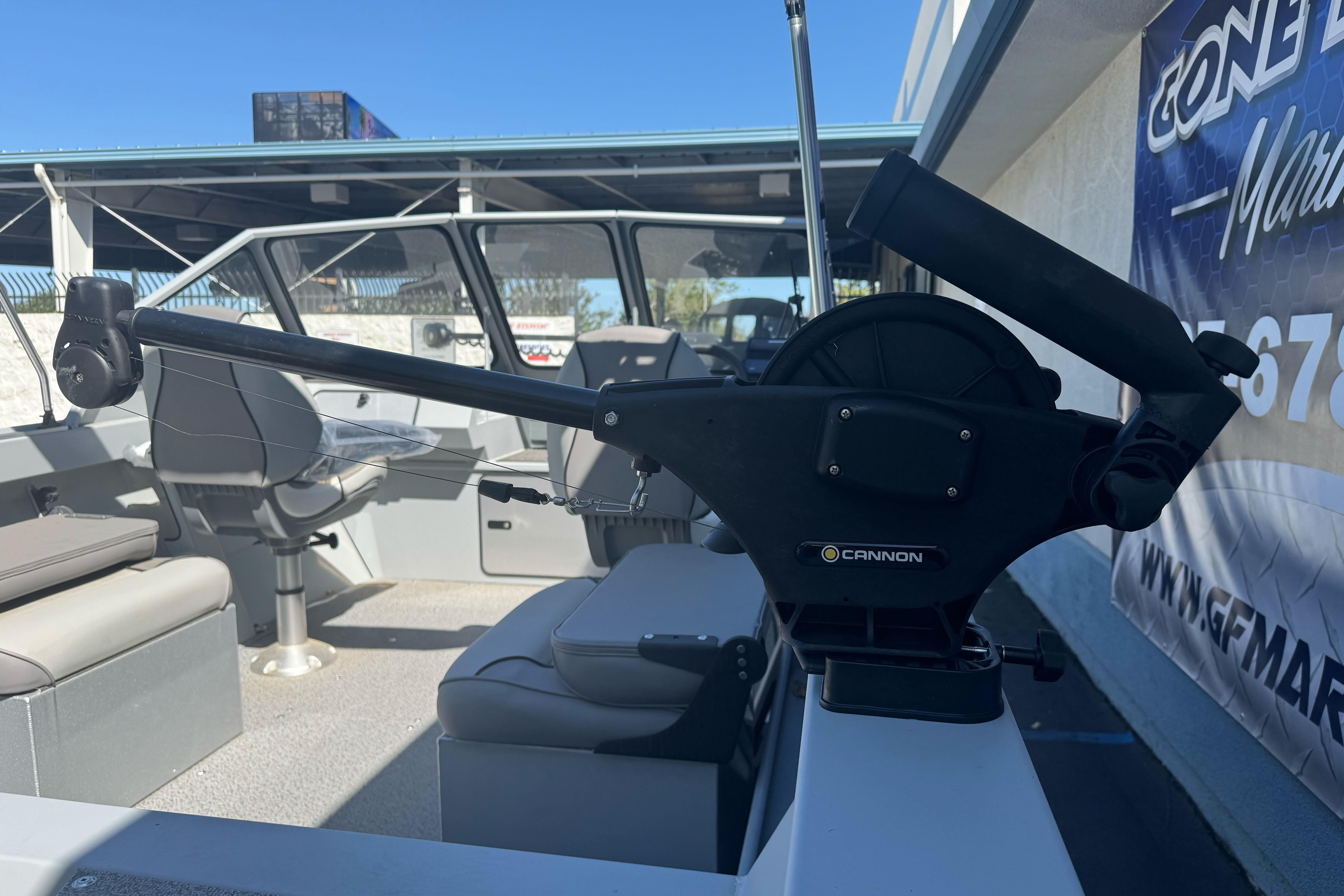 2026 KingFisher 16 Falcon boat interior with Cannon downrigger, showcasing seating and controls.