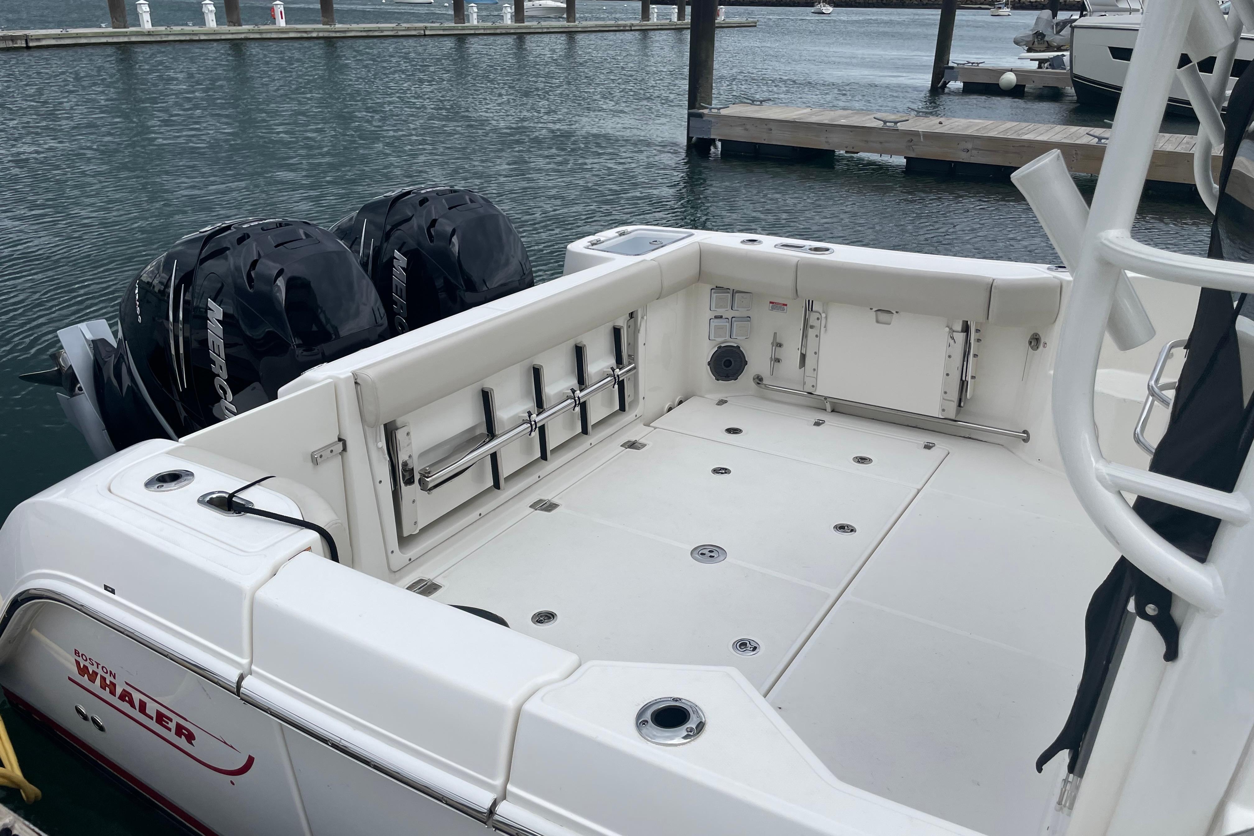 2023 Boston Whaler 325 Conquest boat with dual Mercury engines docked at marina.