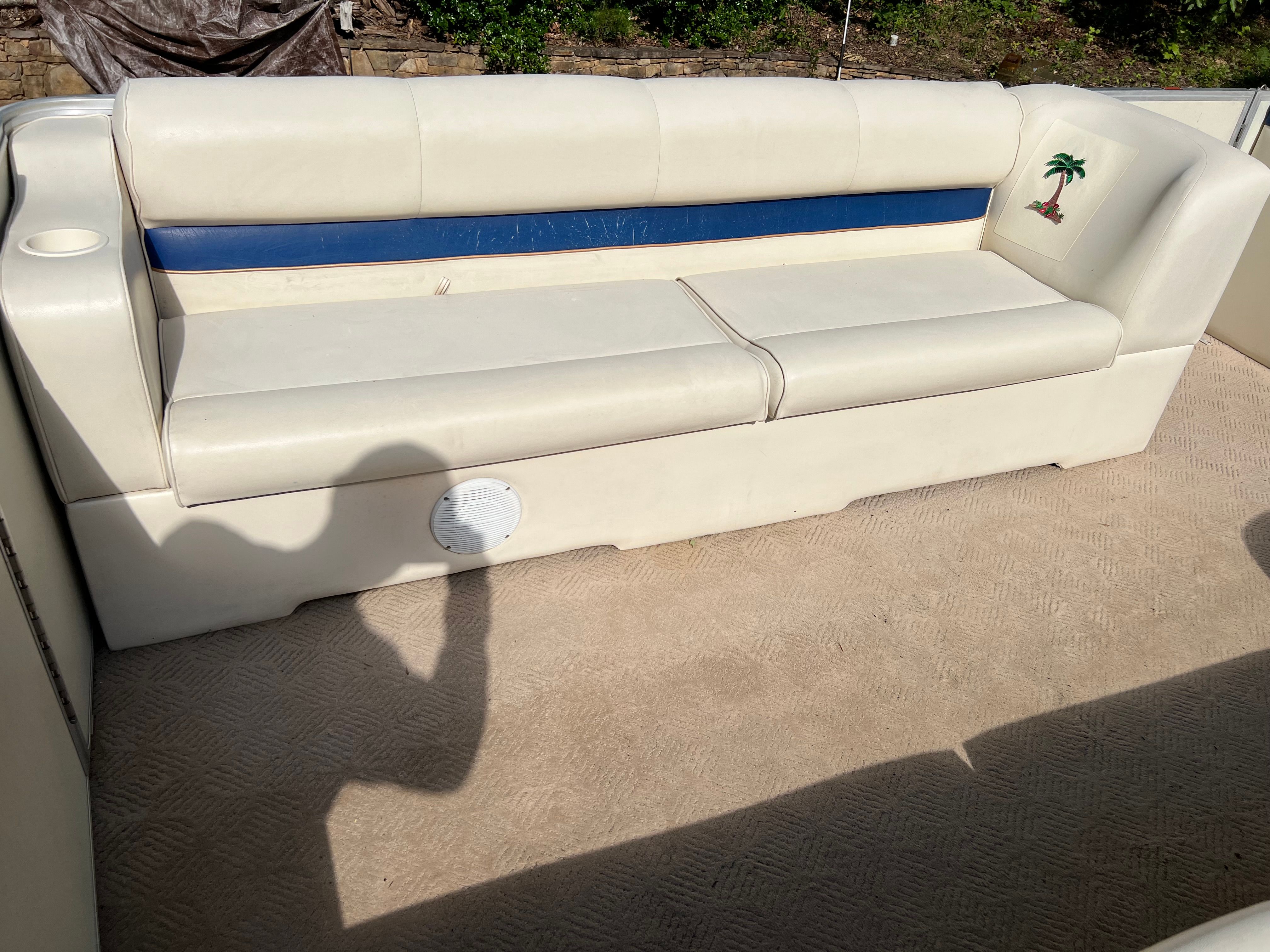 A white boat bench seat with blue trim and palm tree embroidery.