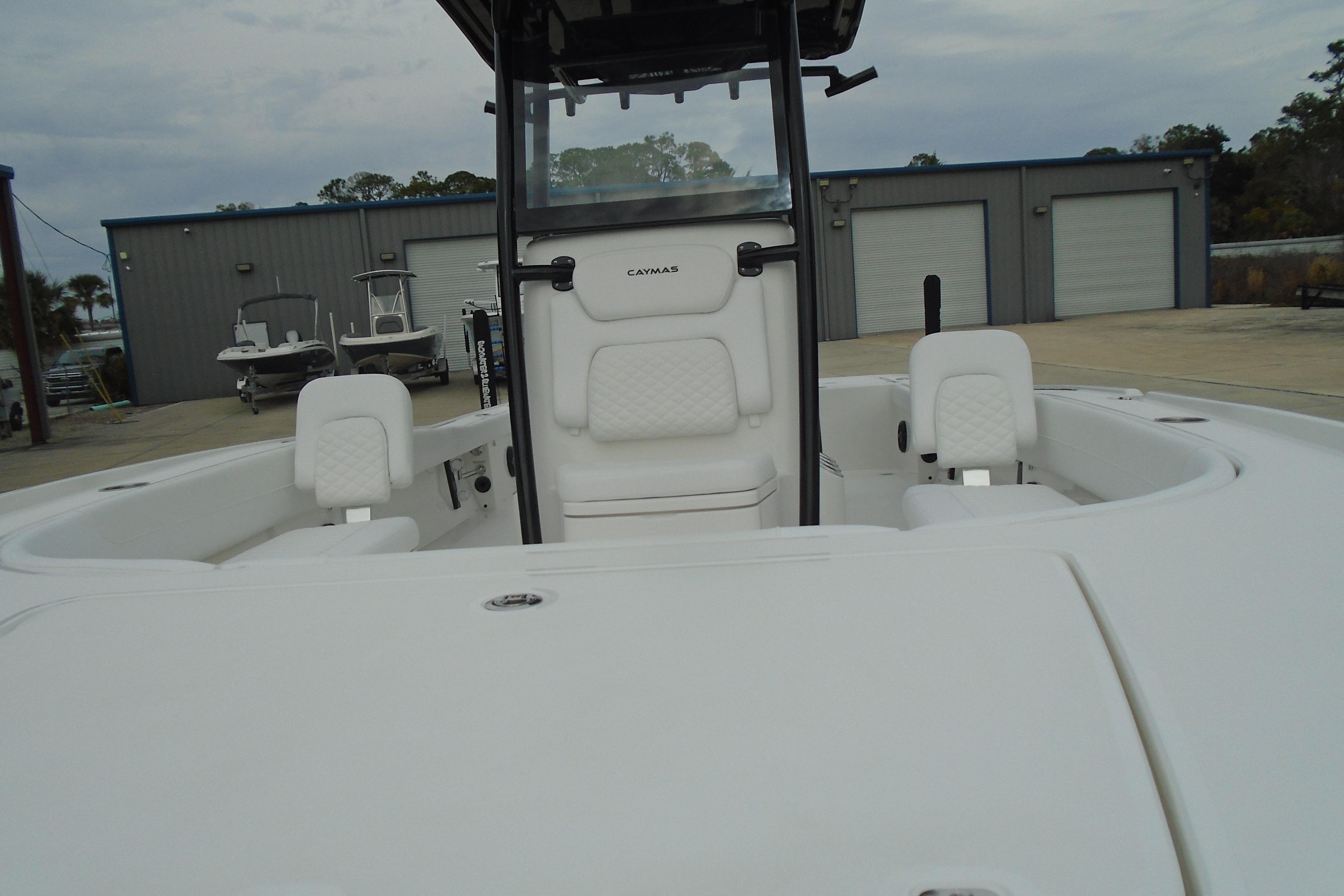 2026 Caymas 26 HB boat interior with white seating and console, docked outdoors.