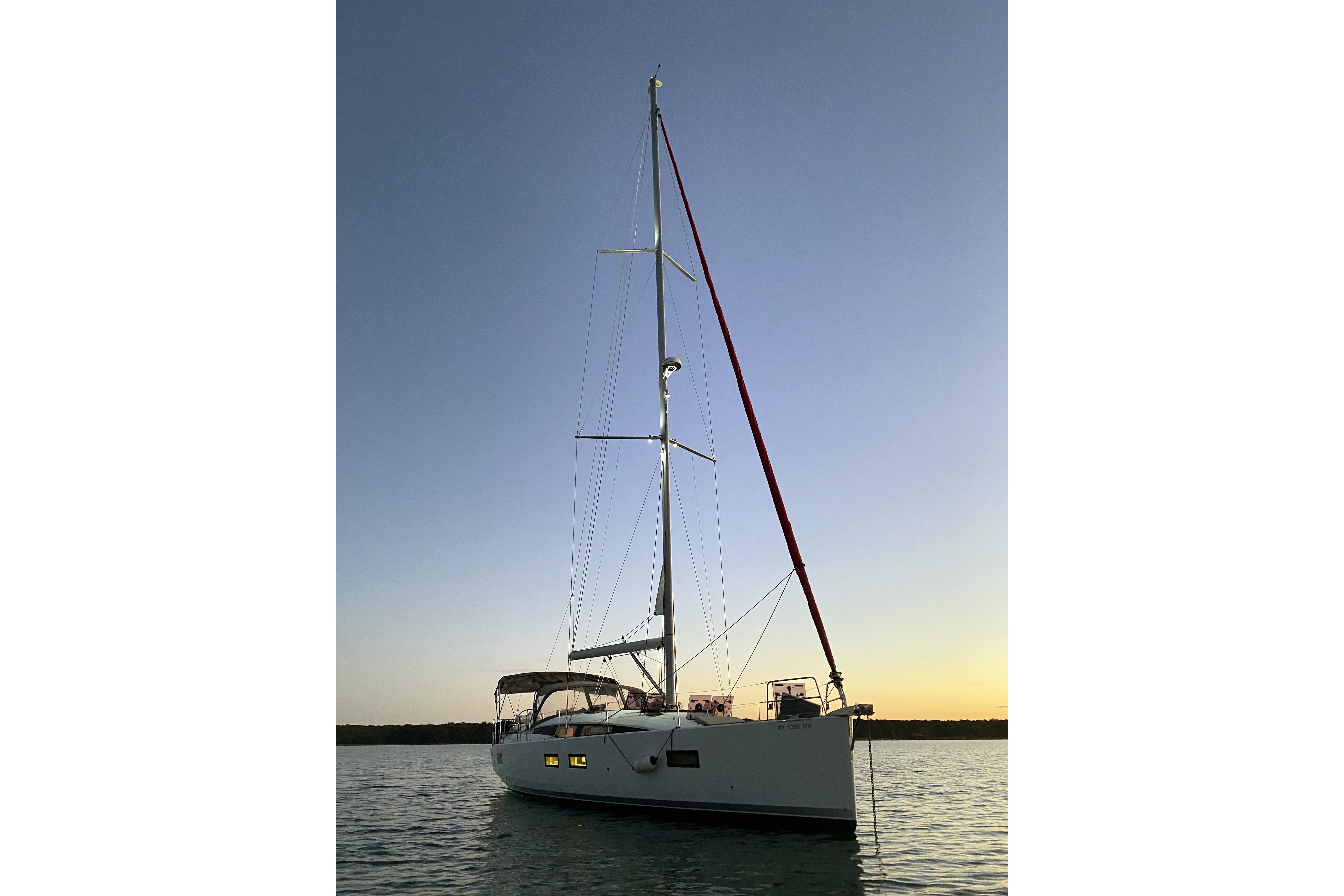 2018 Jeanneau 51 sailboat at sunset on calm waters.